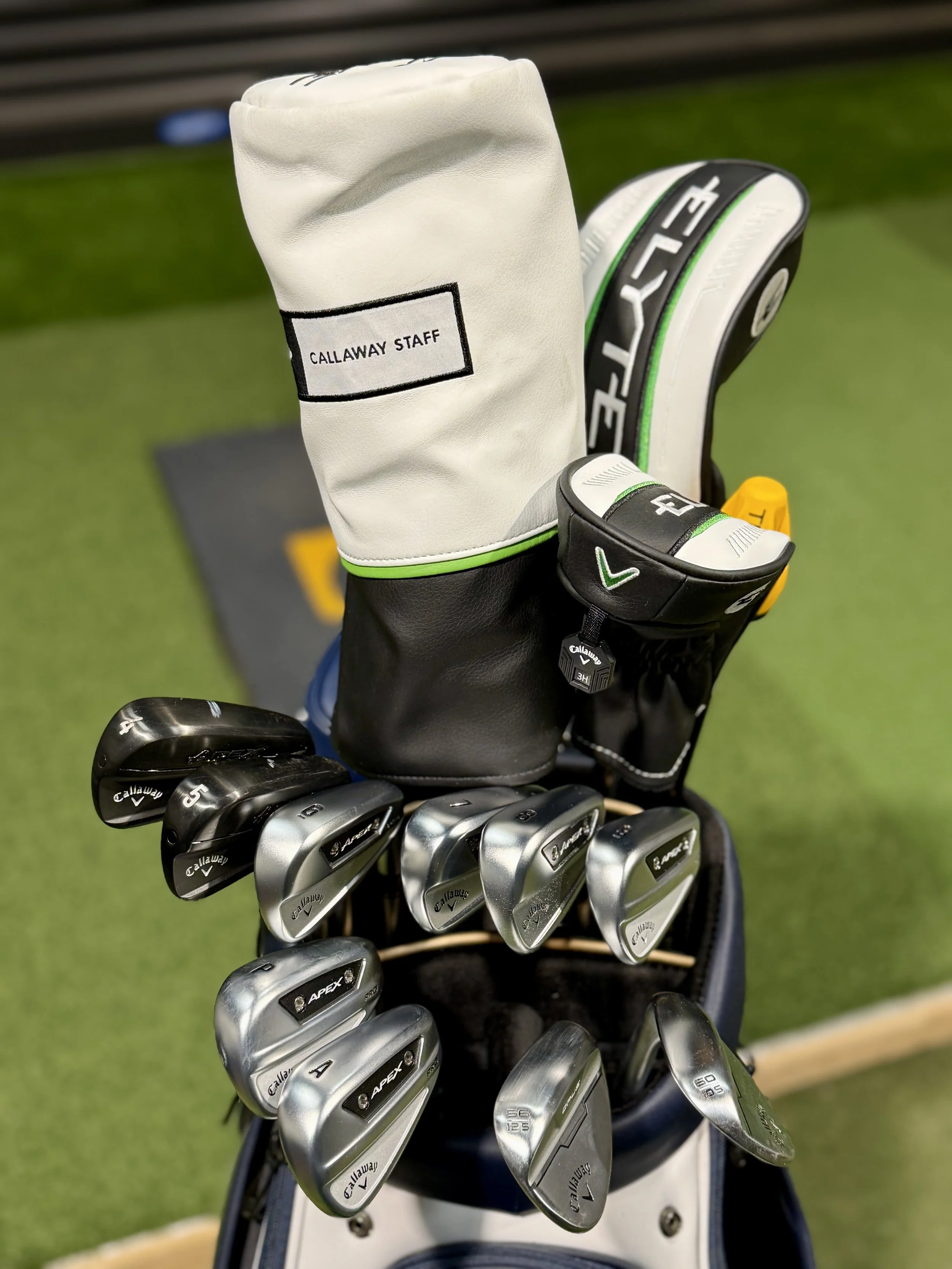 Golfclubs in golfbag, close-up, greens, fairway.