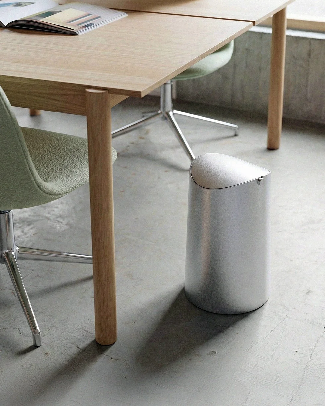Flippy waste bin designed by Andrew Roberts, featuring a cone-shaped rolled steel body with fitted pivoting lid and minimal welded construction for modern interior use.