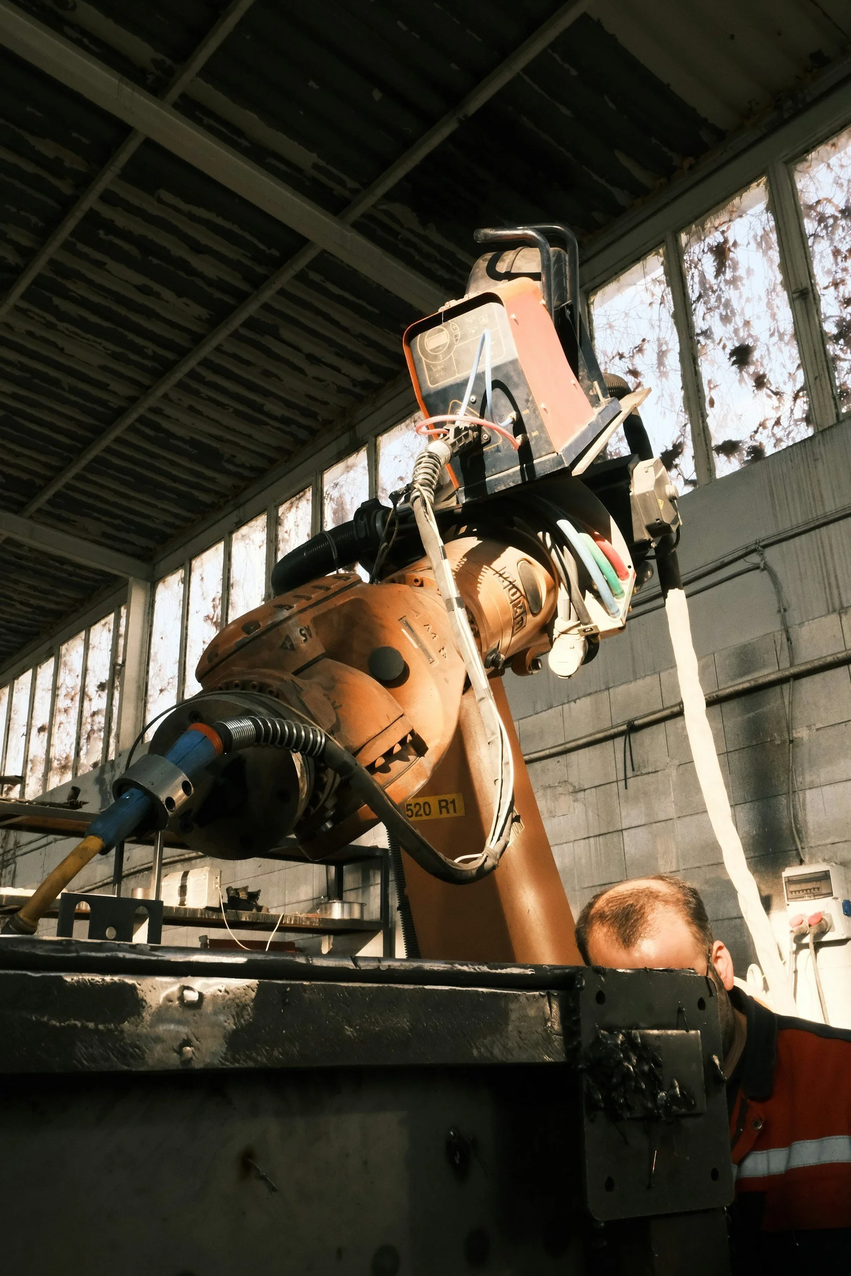 An industrial Kuka robotic arm working MIG welding