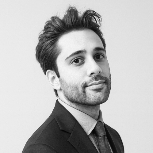 Black and white portrait of a man in a suit with a confident expression, looking slightly to the side.