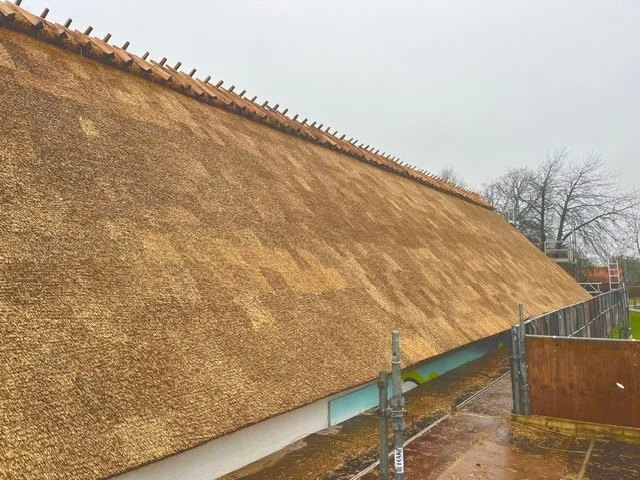 Det er et tag, der er under renovering med en stråtagdækning. Tækkemand Nordsjælland Furesø Tækkeentreprise ApS