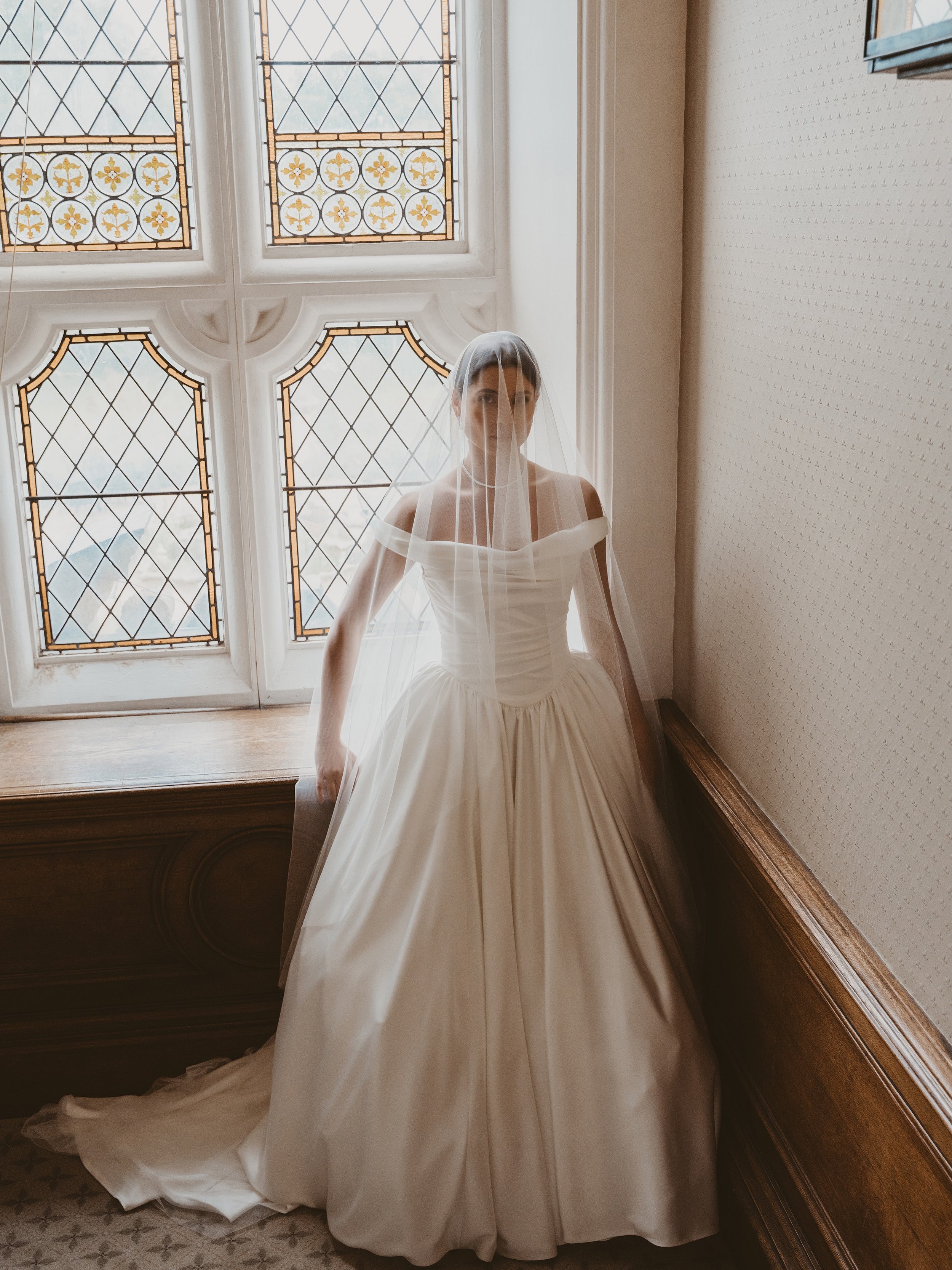 When I designed this gown, I wanted to create a silhouette that felt timeless, yet unmistakably modern.
Crafted in luxurious double satin, every detail has been considered&mdash;from the softly draped off-the-shoulder neckline to the finely pleated b