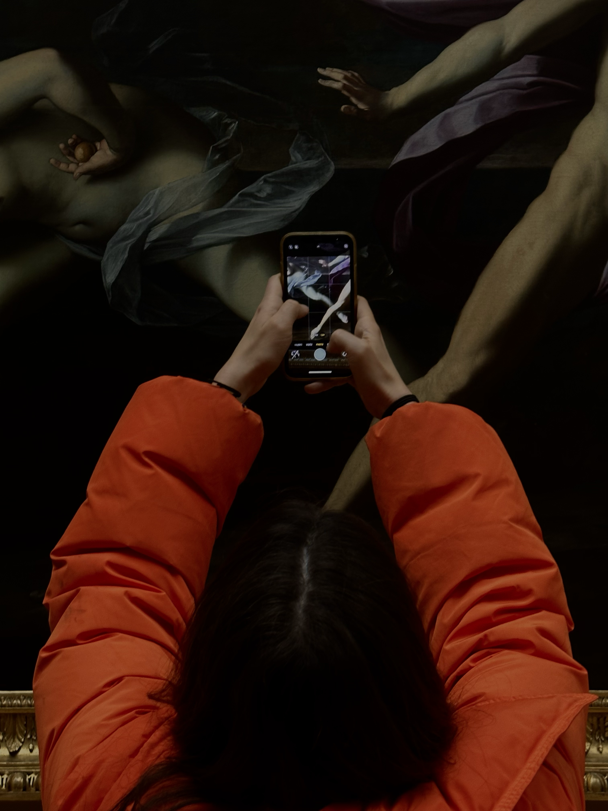 Personne prenant une photo d'une peinture représentant une scène biblique avec un smartphone.