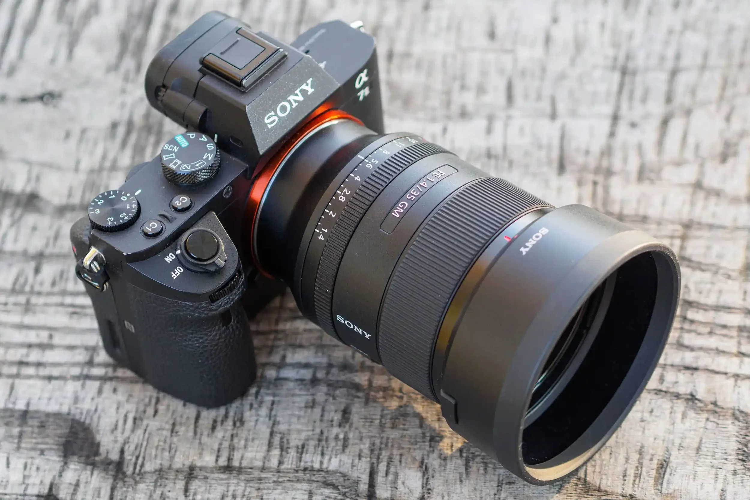 Appareil photo Sony mirrorless avec objectif large, posé sur une surface en bois