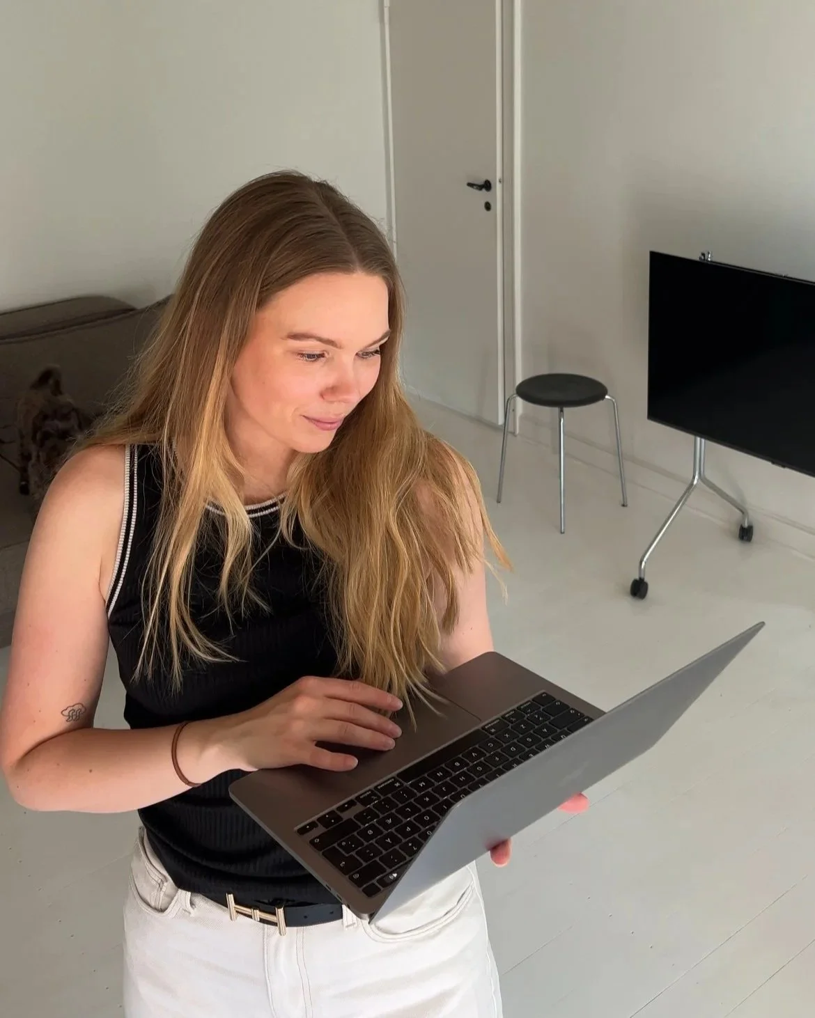 Clara Holmslund, Brand designer og Founder af Projekt01, står og kigger på sin bærbare computer.