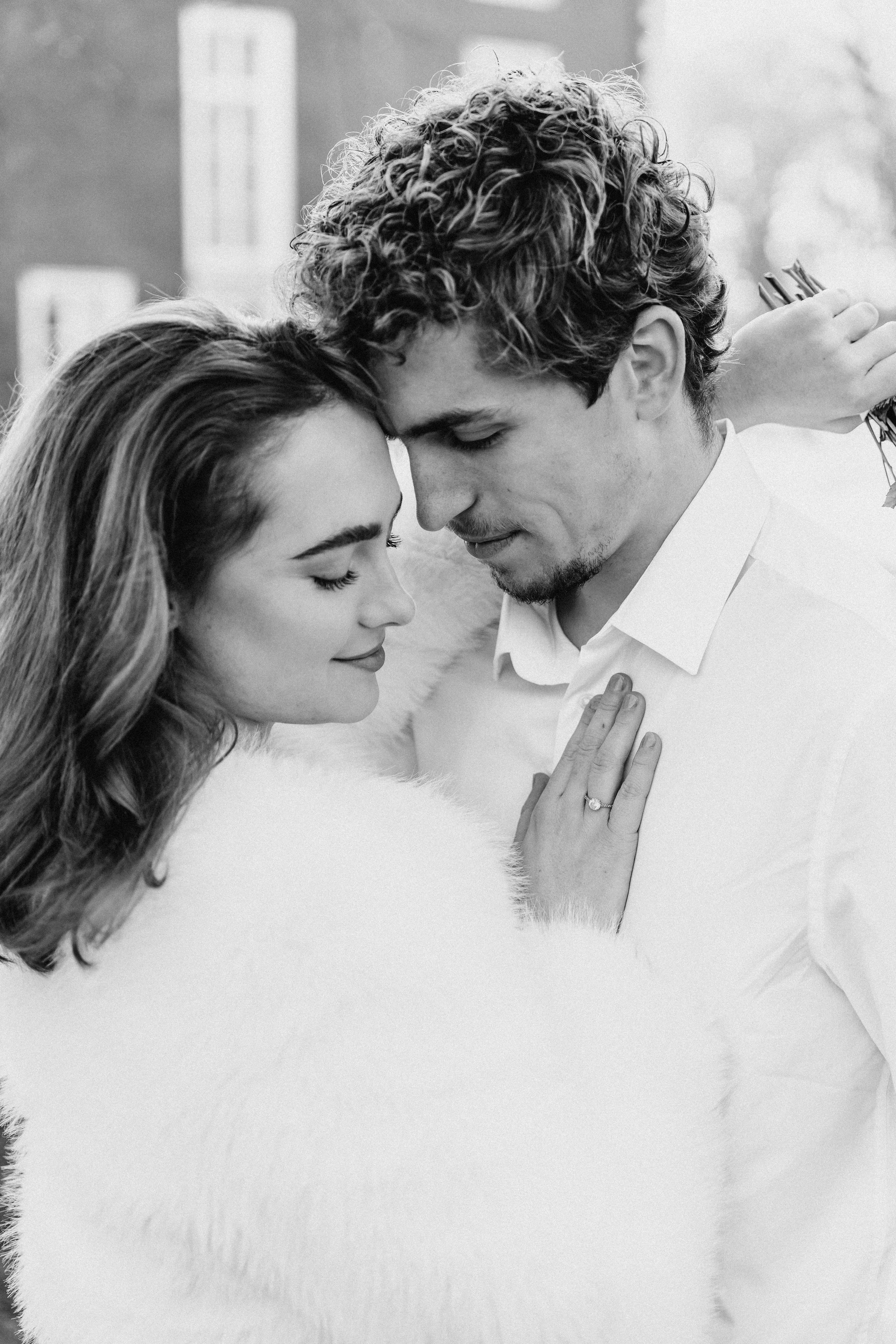 Zwart-wit foto van een bruidspaar dat dicht bij elkaar staat, met ogen dicht, in een intiem moment, de vrouw draagt een verlovingsring op haar vinger tijdens een bruidsreportage van Rosa Lynn Signer.