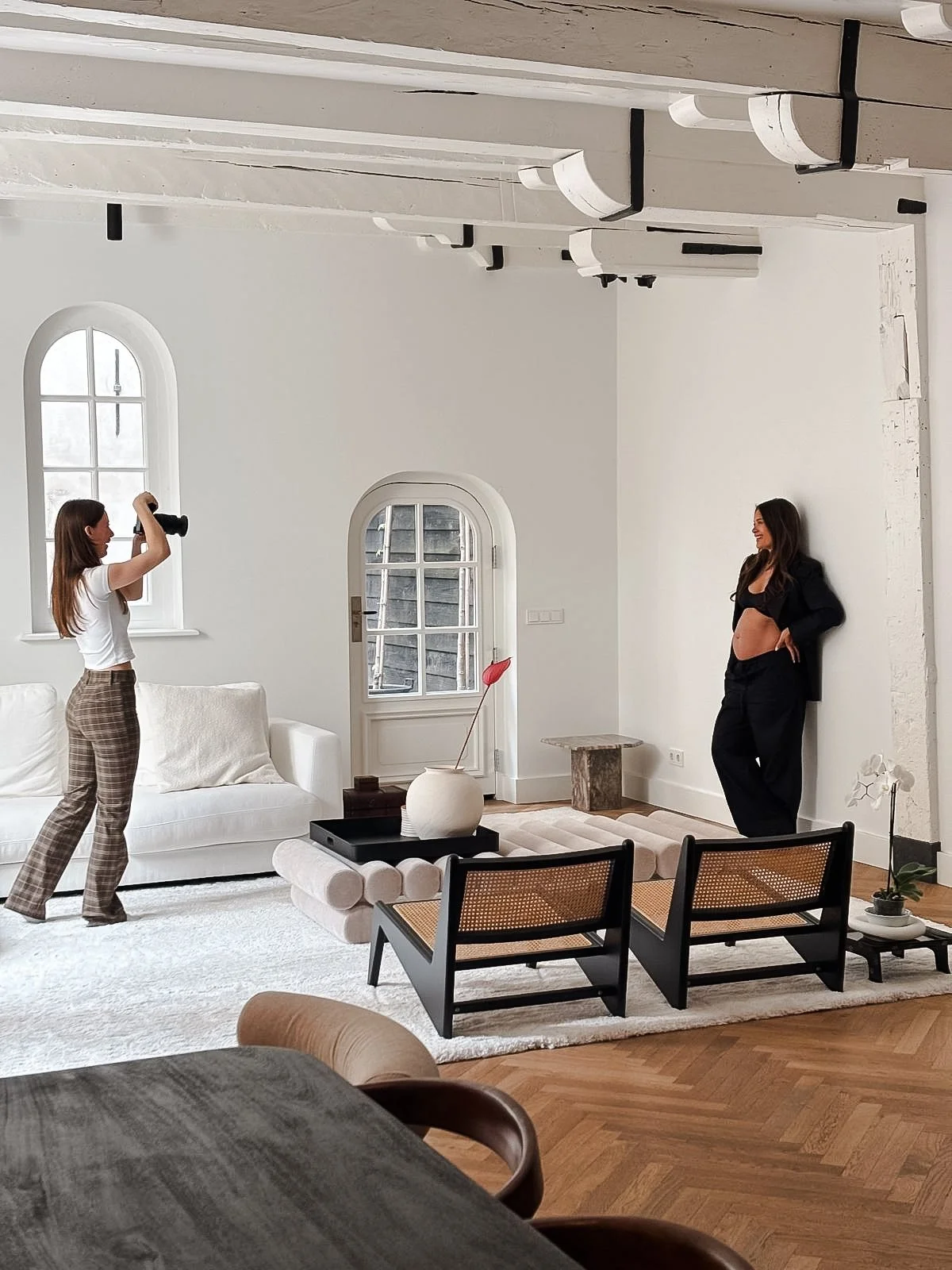 Rosa Lynn Signer fotografeert een zwangere vrouw in een woonkamer tijdens een zwangerschapsshoot.