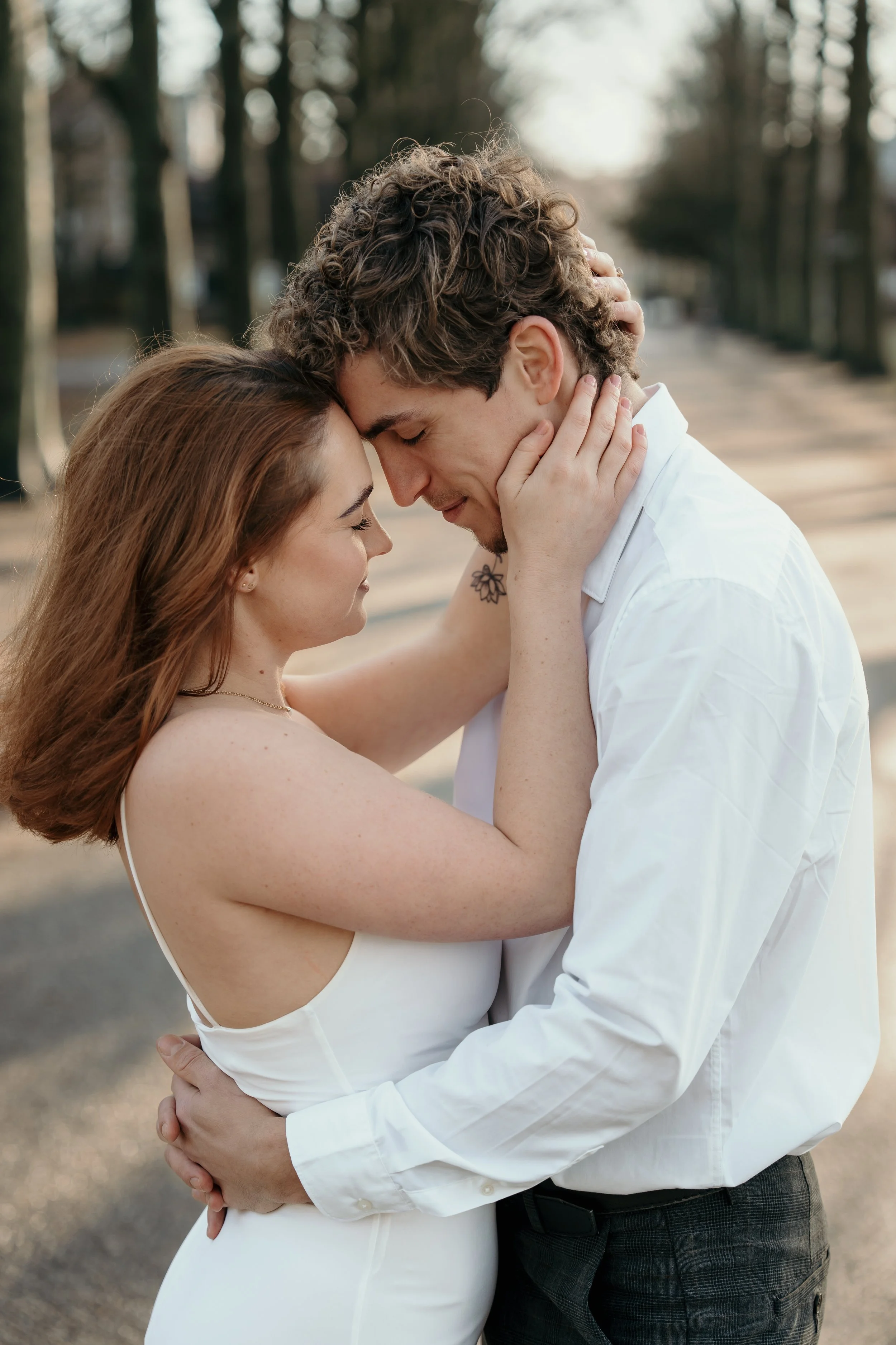 Een bruidspaar houdt elkaar vast en maken oogcontact op een bospad in het park tijdens een bruidsreportage van Rosa Lynn Signer.