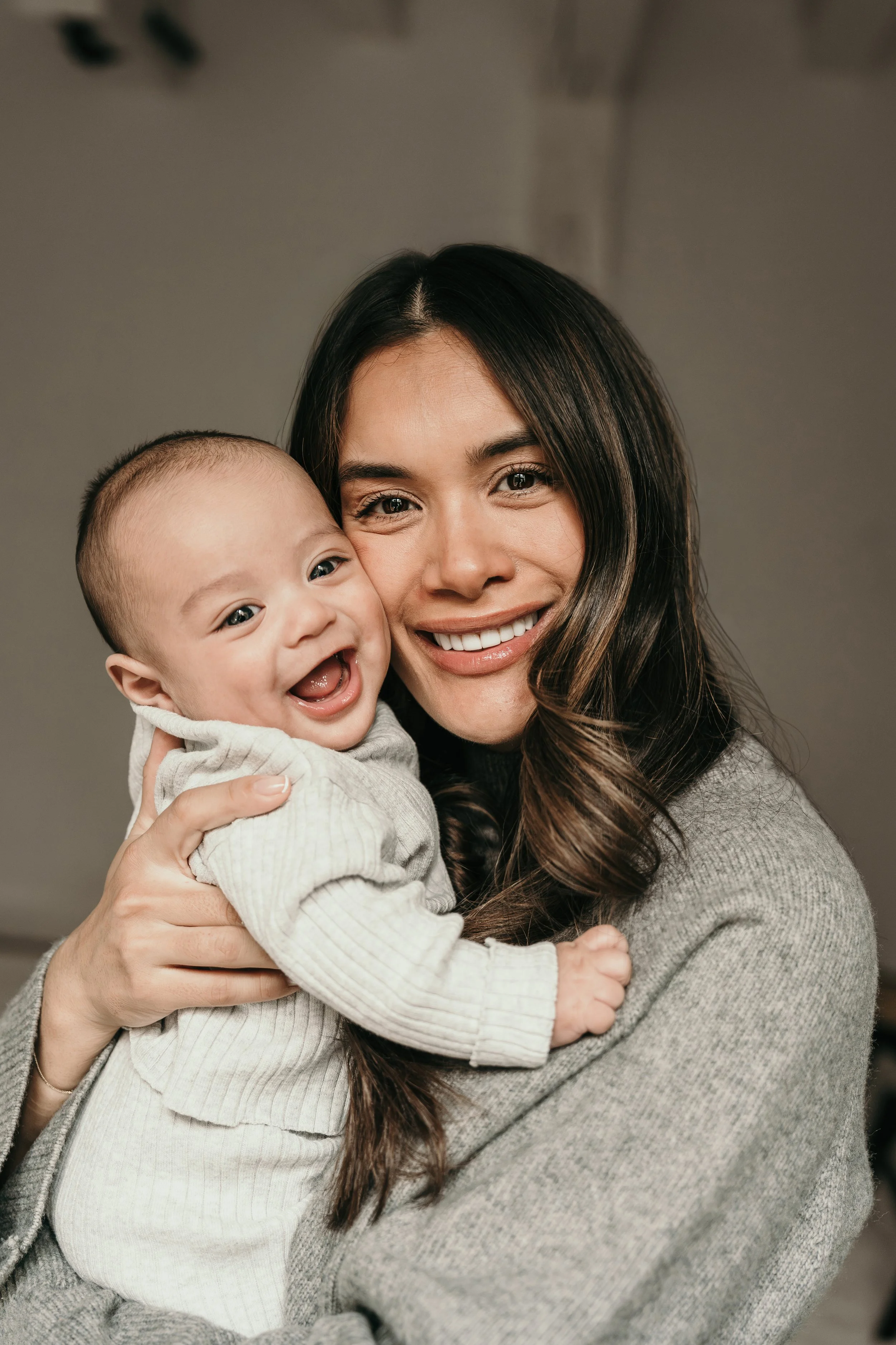 Moeder houd een lachend baby vast tijdens een new born shoot van Rosa Lynn Signer. 