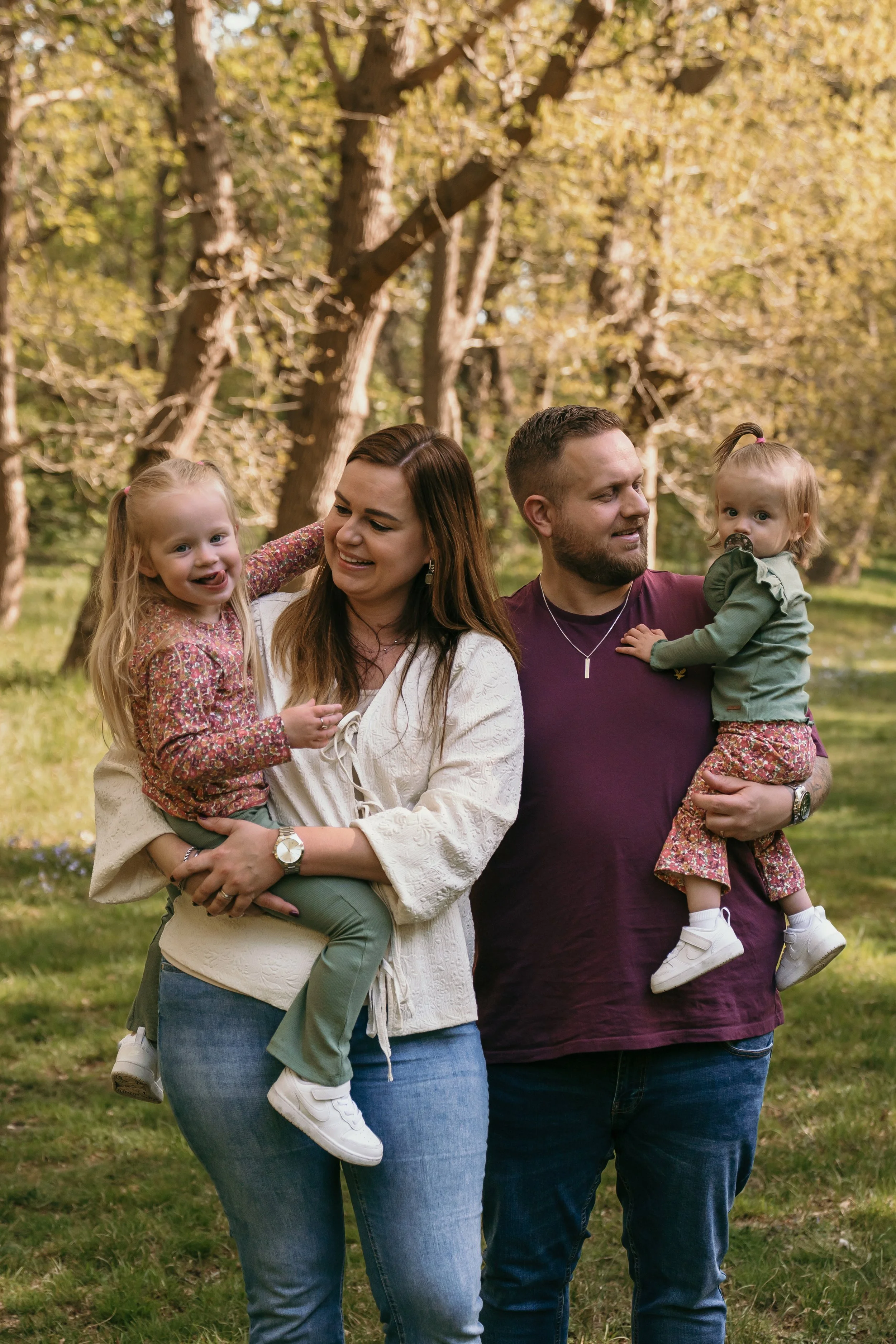 Een gezin tijdens een familieshoot van Rosa Lynn Signer in het bos op een zonnige dag.