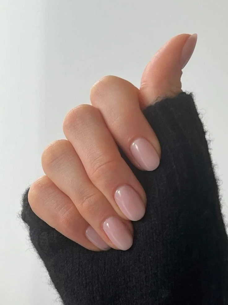 Close-up of a hand showing a thumb-up gesture, wearing a black fingerless glove and having neatly manicured nails.