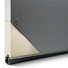 Close-up of a gray and beige textured surface, possibly part of a building or structure.