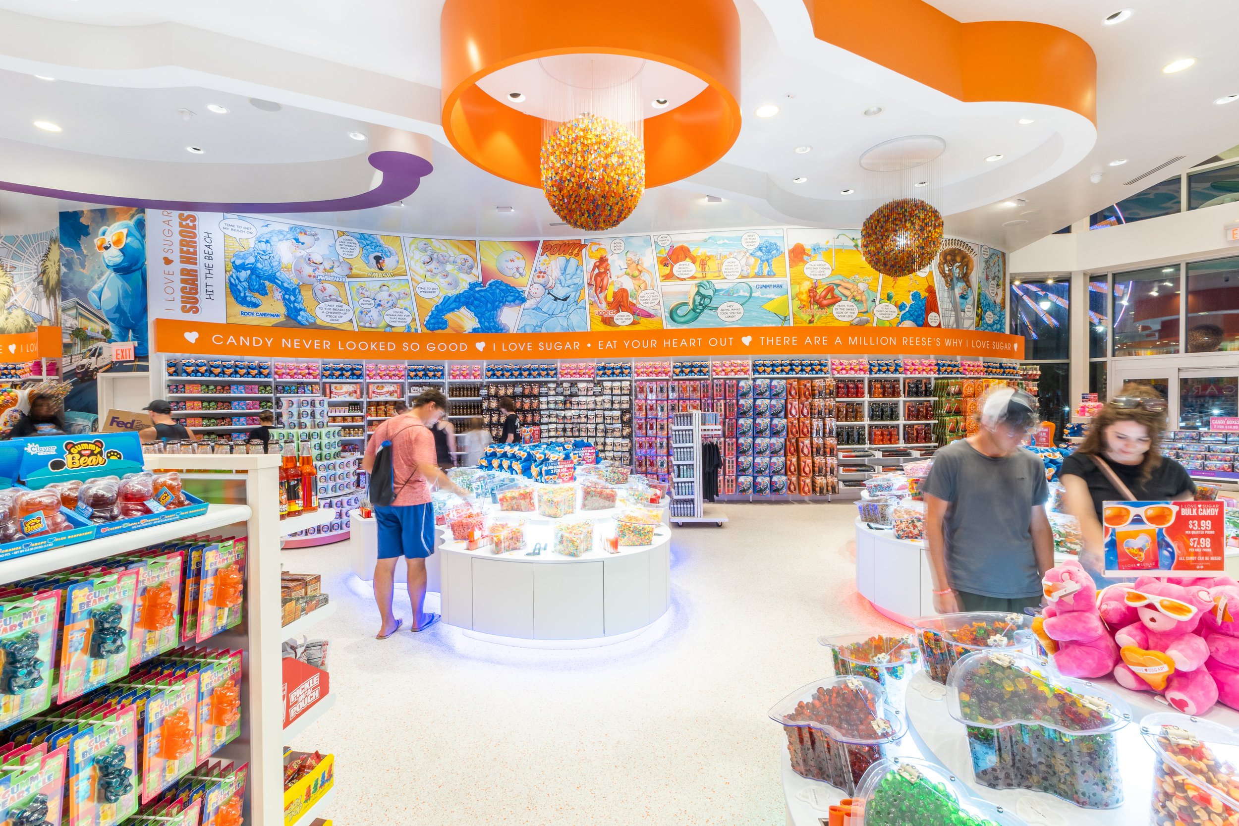 Inside the Myrtle Beach I LOVE SUGAR candy store which features colorful candy store in heart bins, plush toys, and a comic strip mural on the wall.