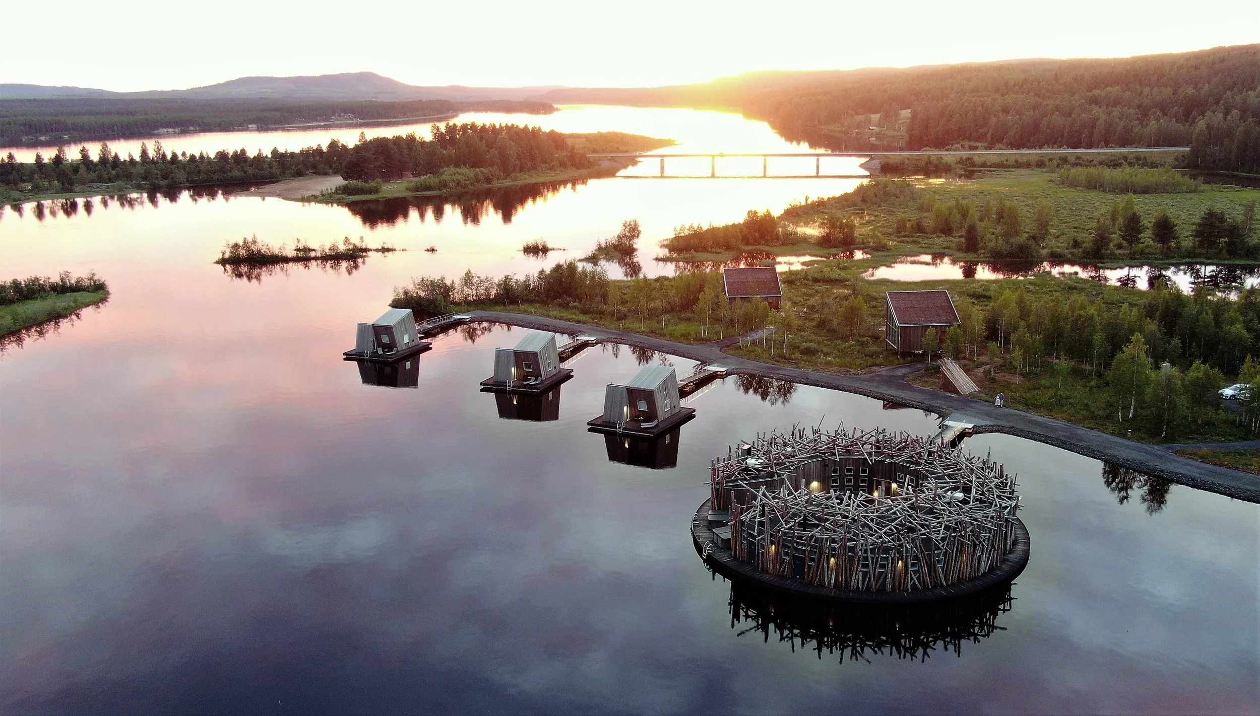 Little huts situated on a lake in Sweden with a sunset in the background