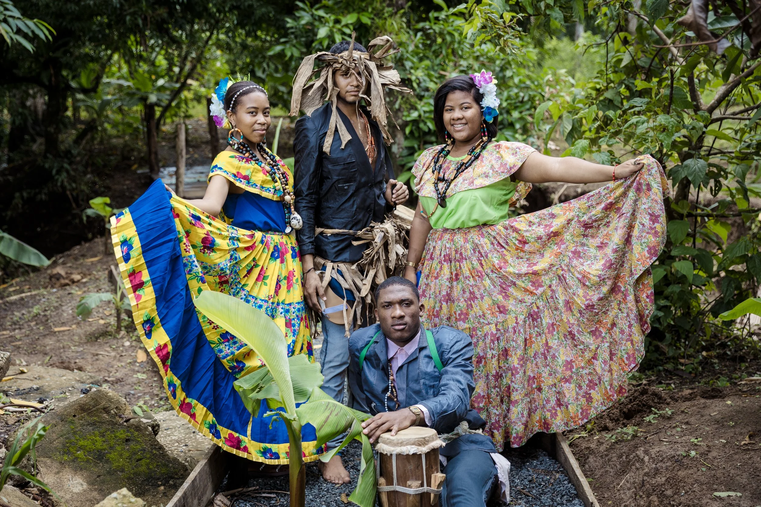 Two women and two men wearing traditional Conga indigenous attire from Panama pose for a picture in the forest.
