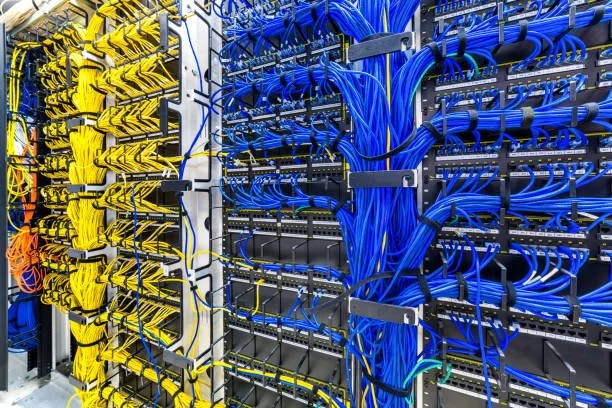 A server rack filled with yellow and blue network cables connected to switches and servers.