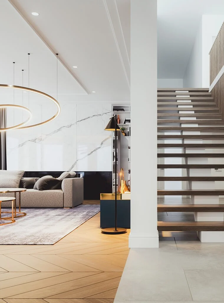 Modern living room with a staircase on the right, a gray sofa with pillows, a marble accent wall, a circular chandelier, and a tall floor lamp.