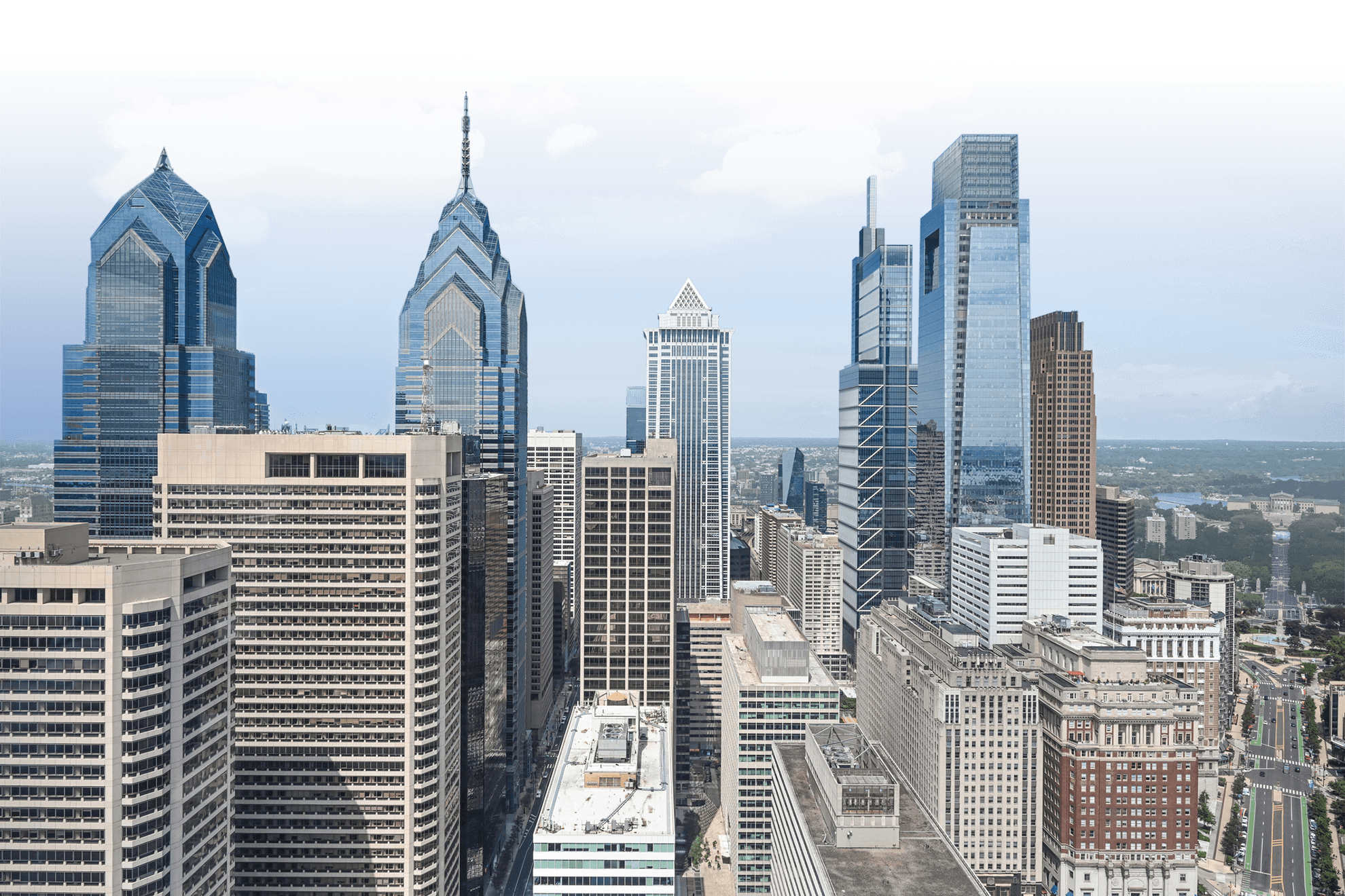 Skyscrapers in a city skyline with blue sky and clouds.