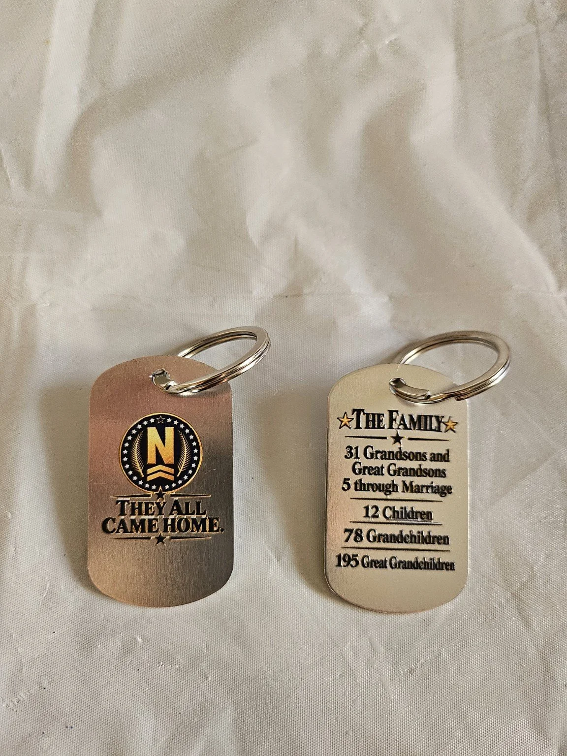 Front and back of Nolte 36 metal dog tag key chains.