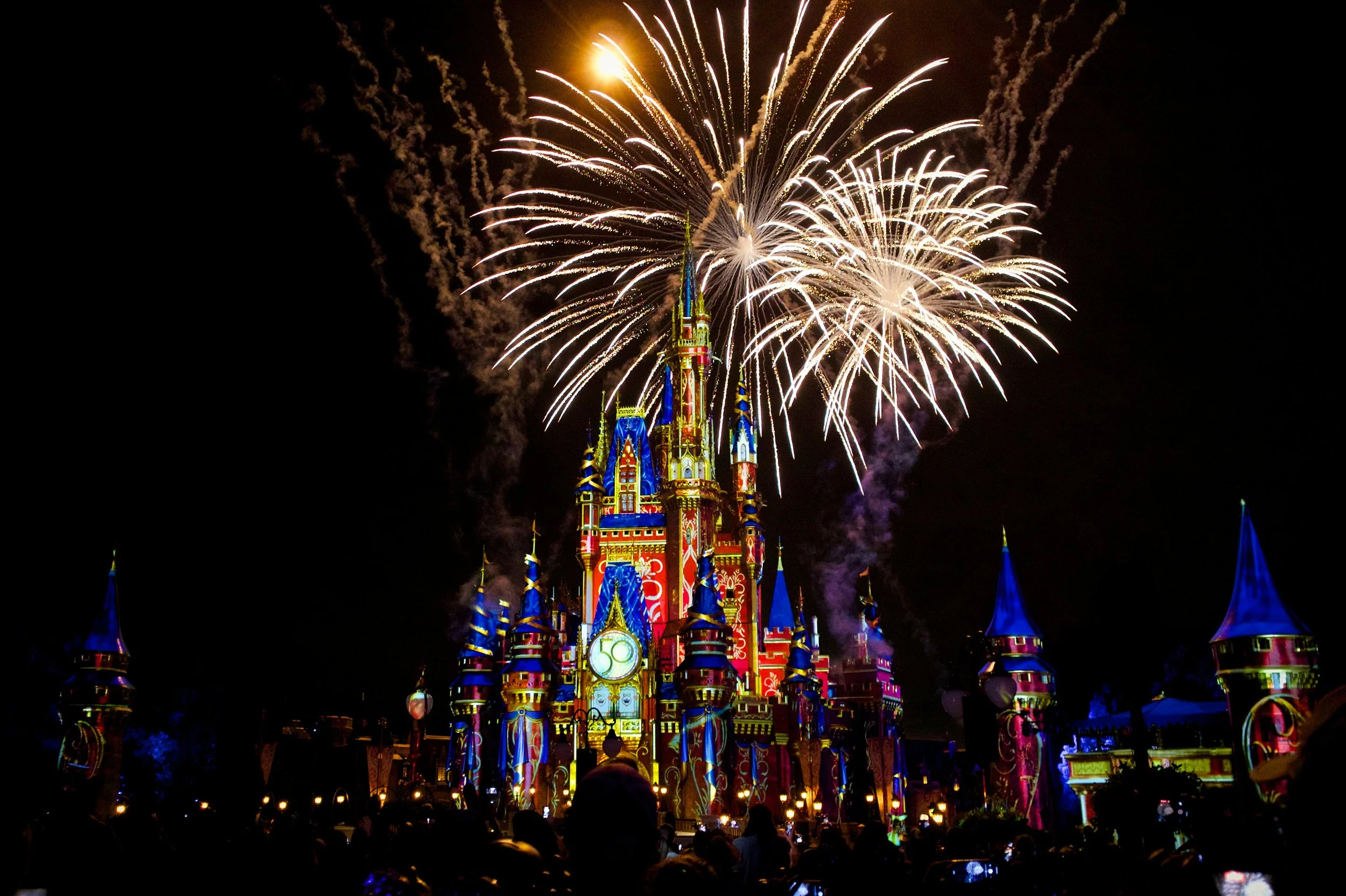 Fireworks explode over Sleeping Beauty Castle decorated for Disney 50th anniversary at Disneyland.