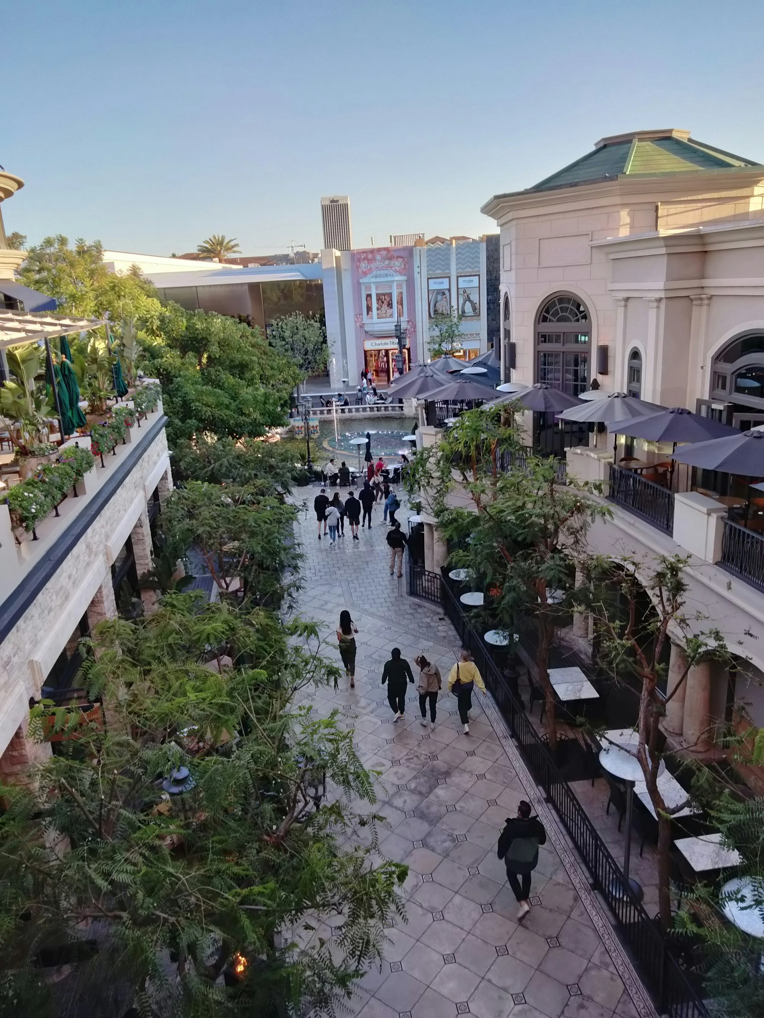 Image of people walking down cobblestone path in LA outdoor shopping center.