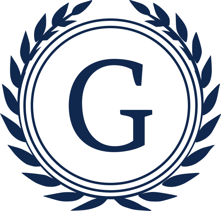 A navy blue circular logo with a large letter 'G' in the center, surrounded by a wreath made of laurel leaves.