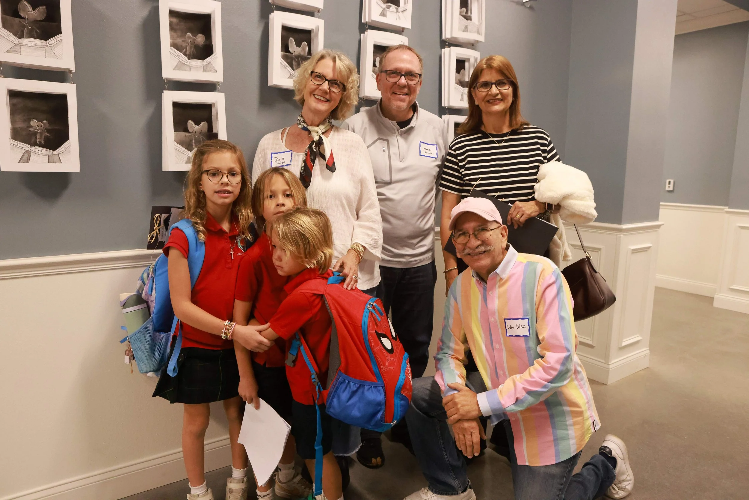 A group of people, smiling and posing for a photo indoors.