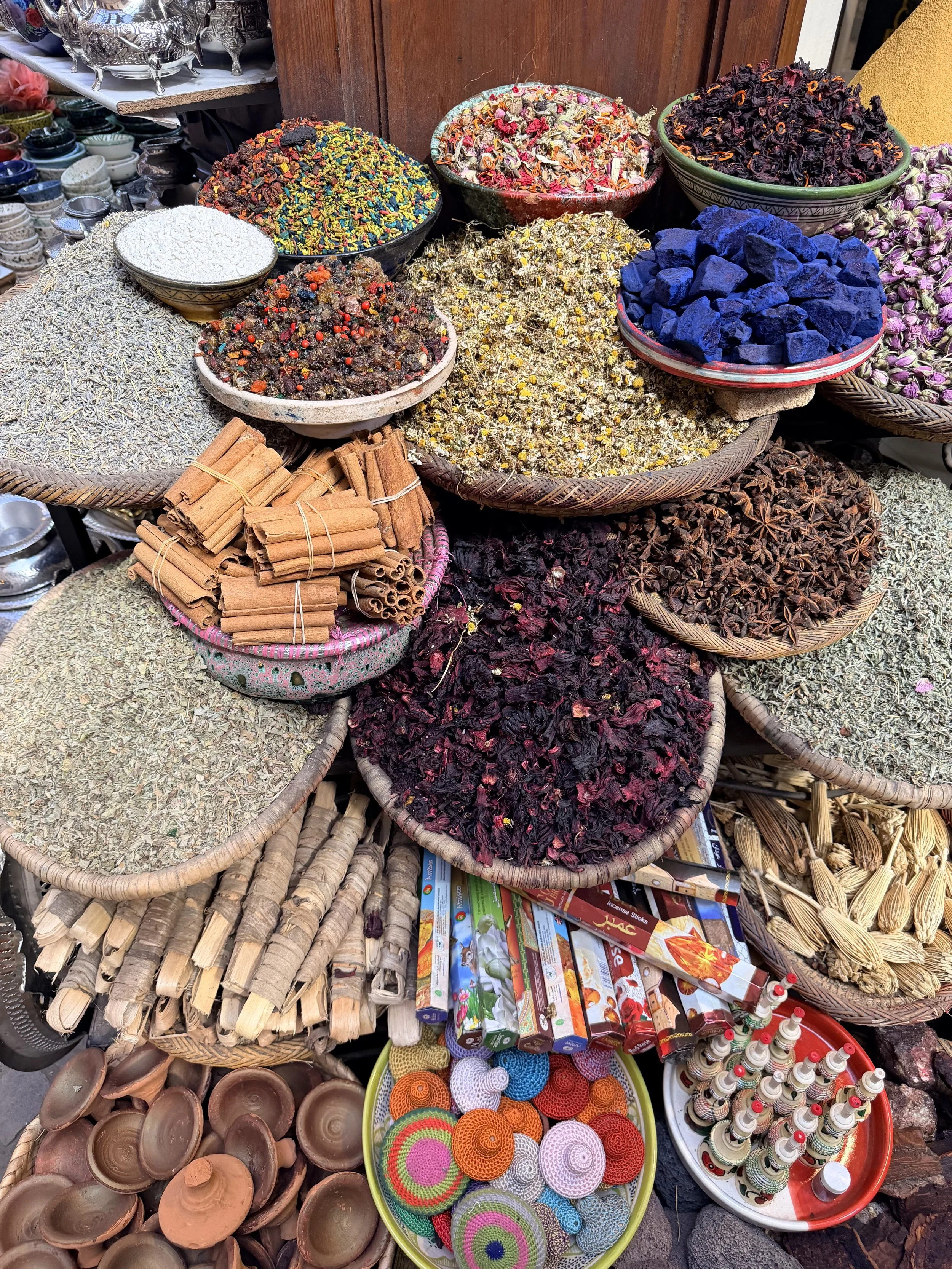 Spices, dried herbs, and traditional market goods displayed at a Moroccan spice stall.