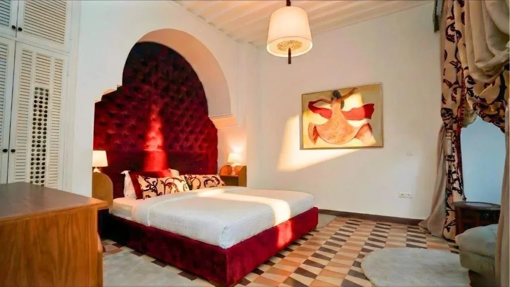 Riad Chama accommodations with a plush bed and beautiful wall decor