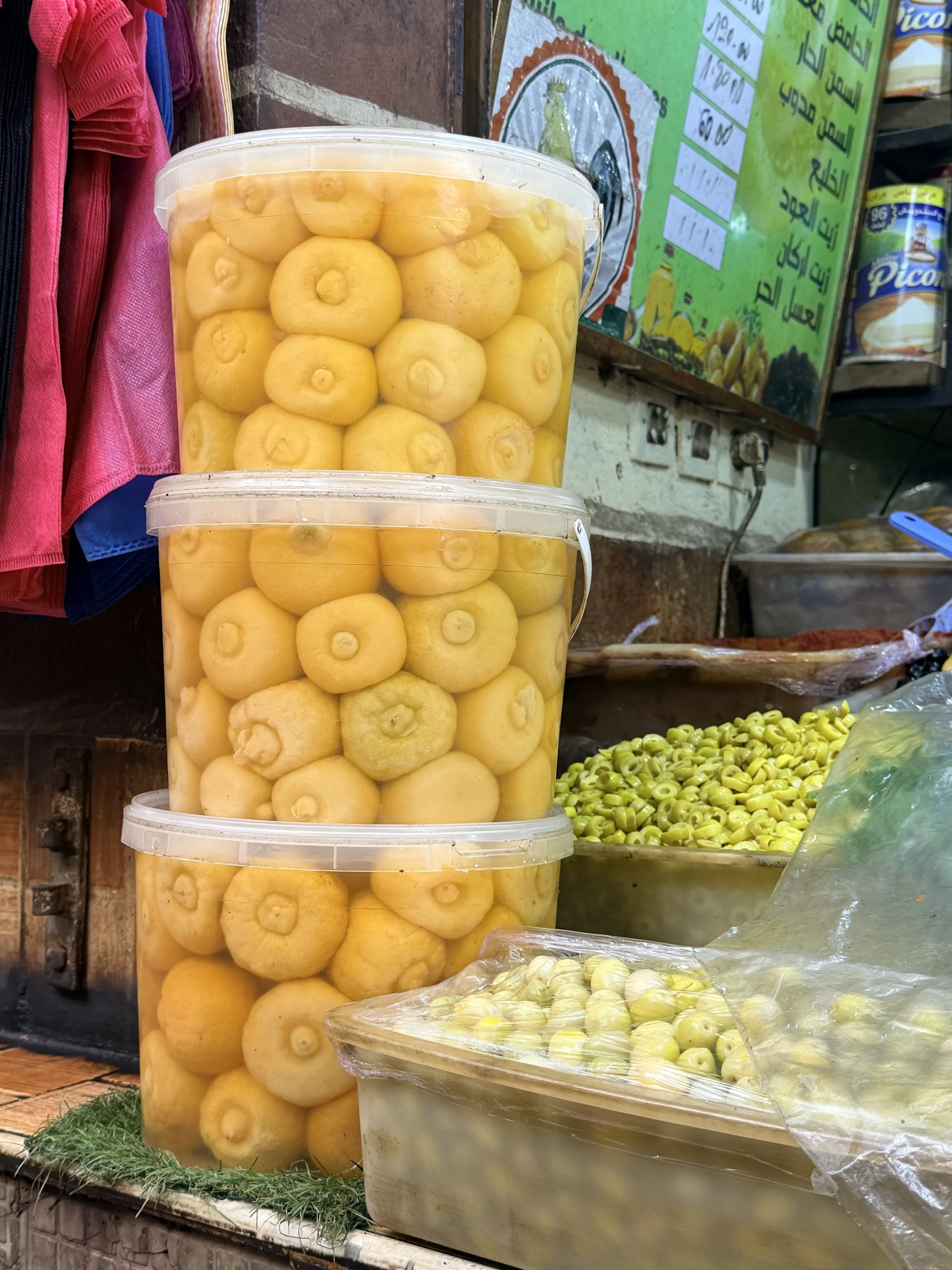 Preserved lemons displayed at a Moroccan market stall, a staple ingredient in Moroccan cooking and tagines.
