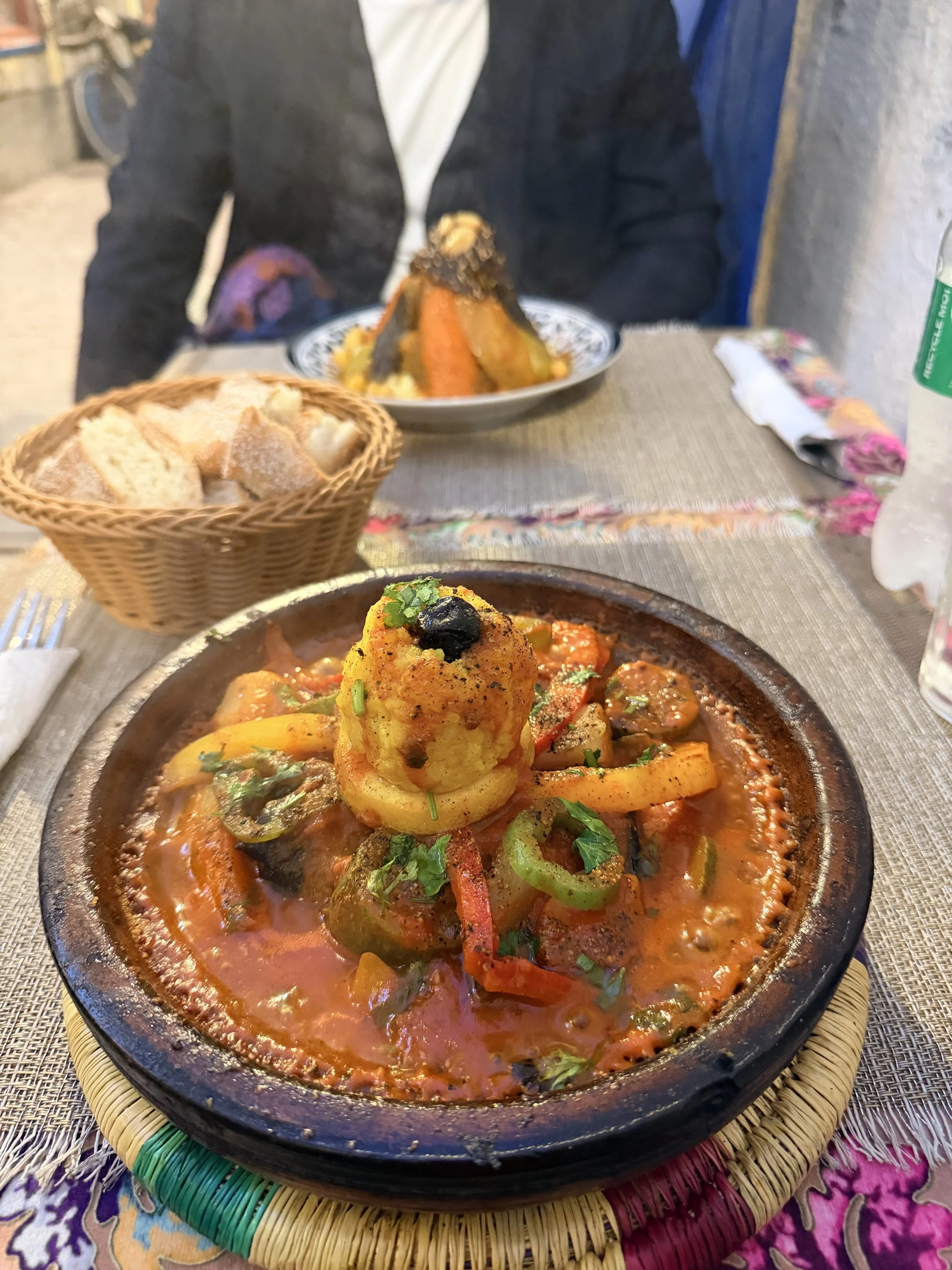 Moroccan tagine served with vegetables, herbs, and bread as part of a traditional food experience in Morocco.