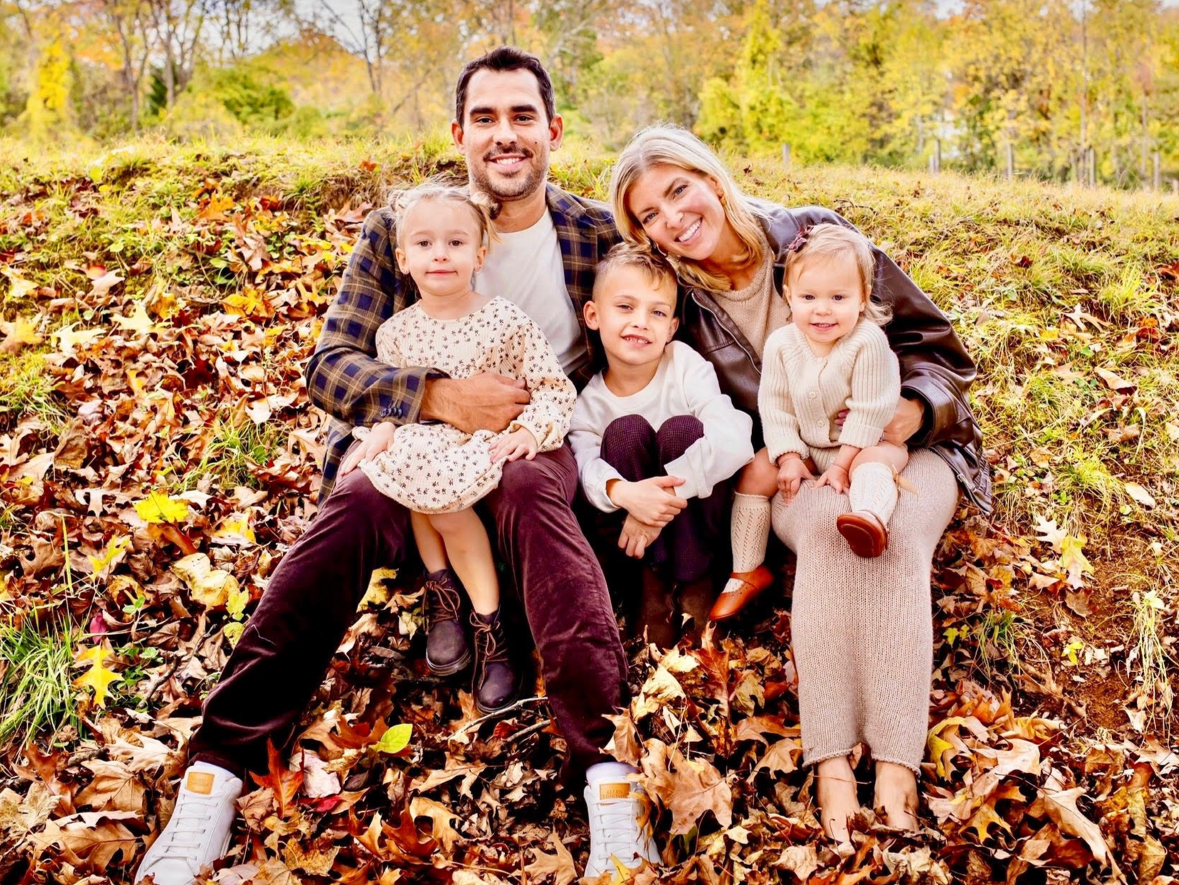 Matt Chiumento and his family sitting outside on a fall day, posing for a family photo.