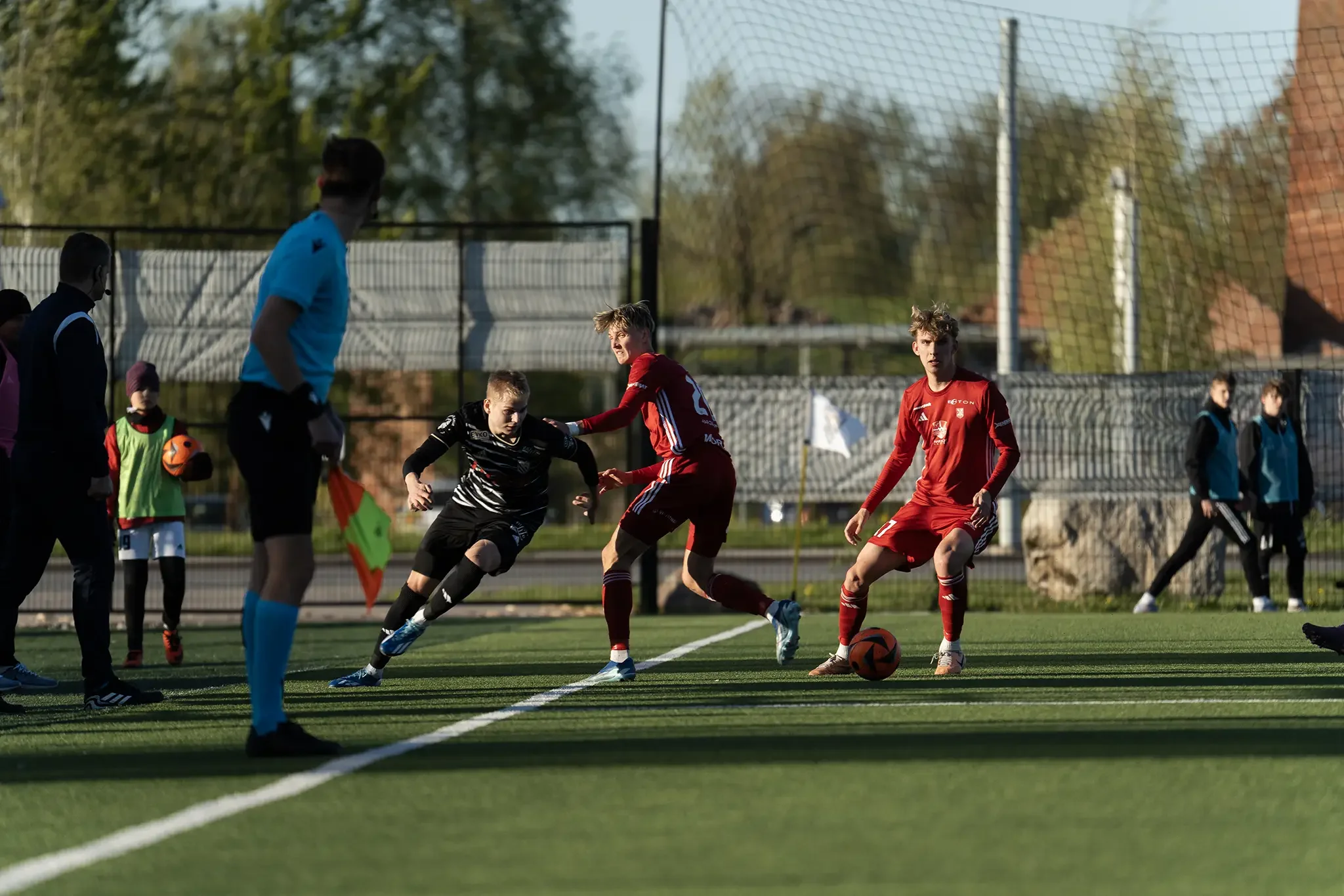 spordifotograafia hetk tartu jk welco ja harju jk laagri vahelises mängus jalgpallurid võitlevad palli pärast väljakul kohtumise ajal kohtuniku kõrval tartu kunstmurustaadionil holm park