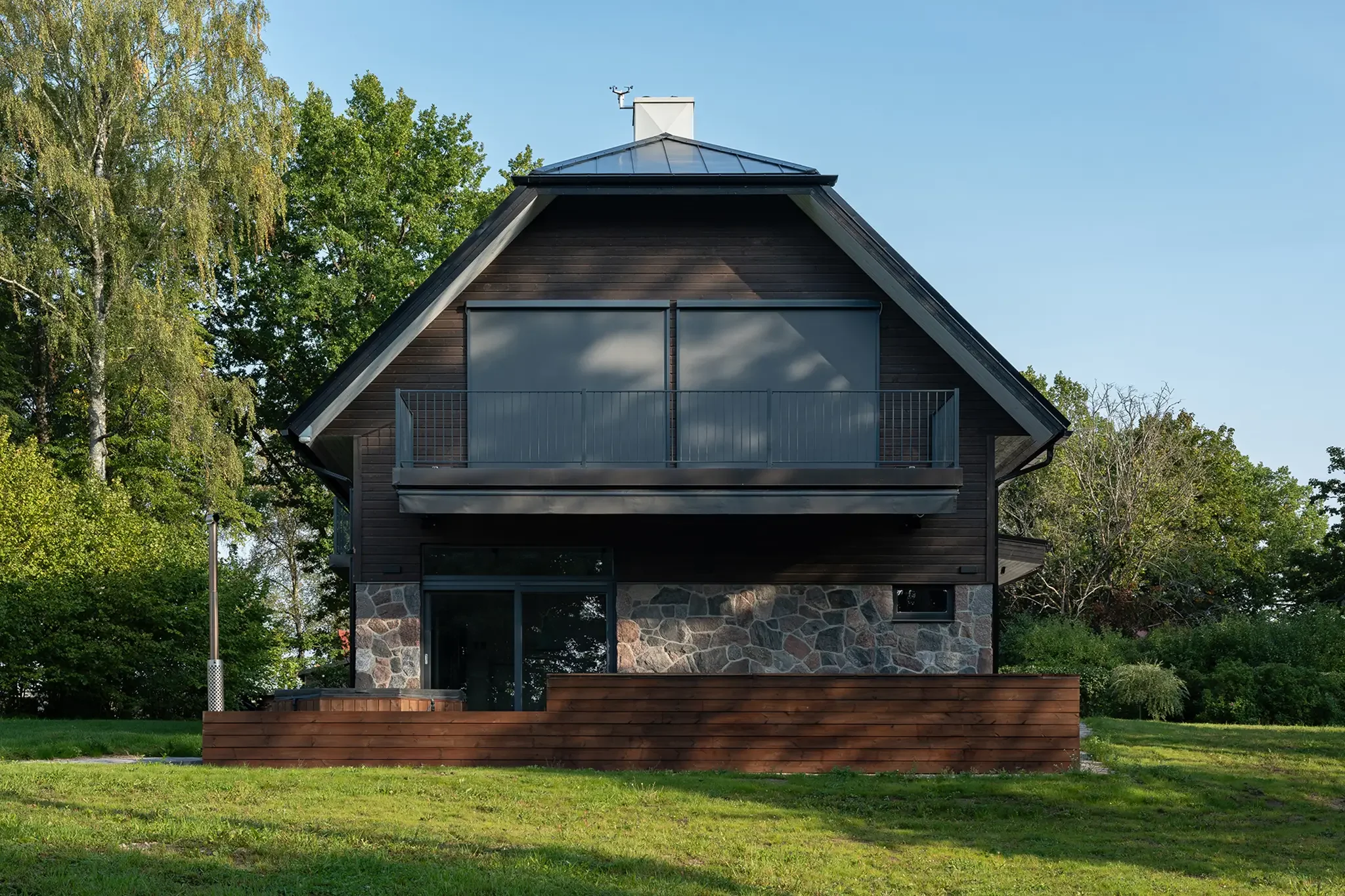 kinnisvara foto kahekorruselisest eramajast Otepääl rohelisel murul puude keskel päikeselisel päeval