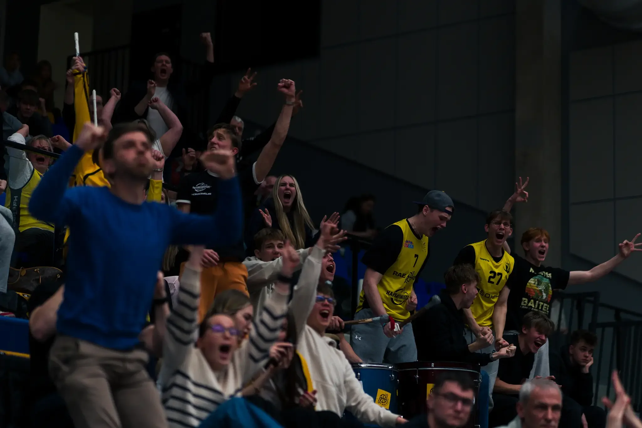 korvpallifännid ja trummarid tähistavad tribüünil spordihallis valjult ja energiliselt