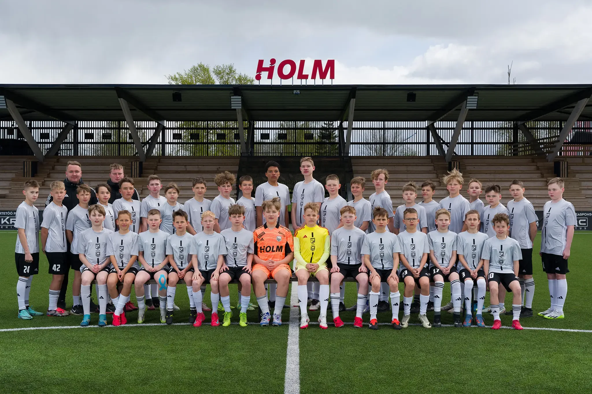 noorte jalgpallimeeskond Tartu WJK Santos poseerib staadionil grupipildil tribüüni ees Holm Park staadionil