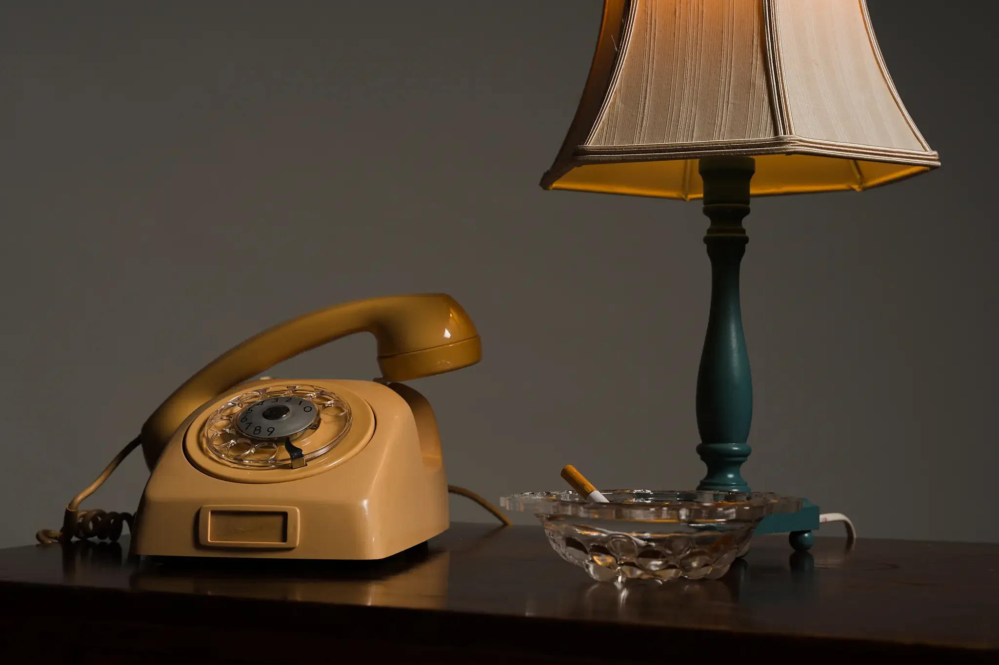 stuudiofoto kollasest lauatelefonist laualambist ja tuhatoosist