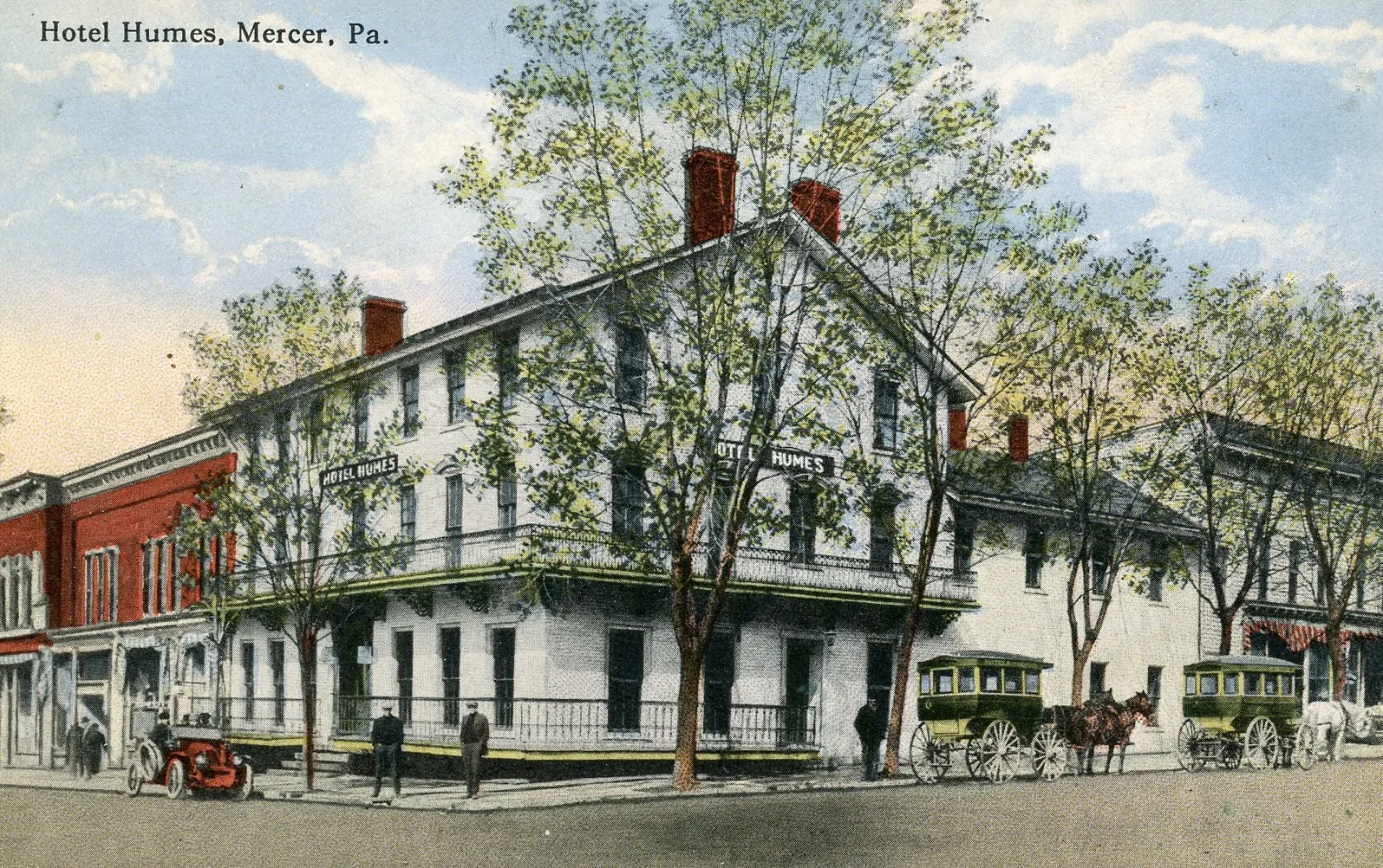 Historic postcard of Hotel Humes in Mercer, Pennsylvania, featuring a three-story building with white facade, red brick accents, and a balcony, with trees, horse-drawn carriages, and pedestrians in early 20th-century attire.
