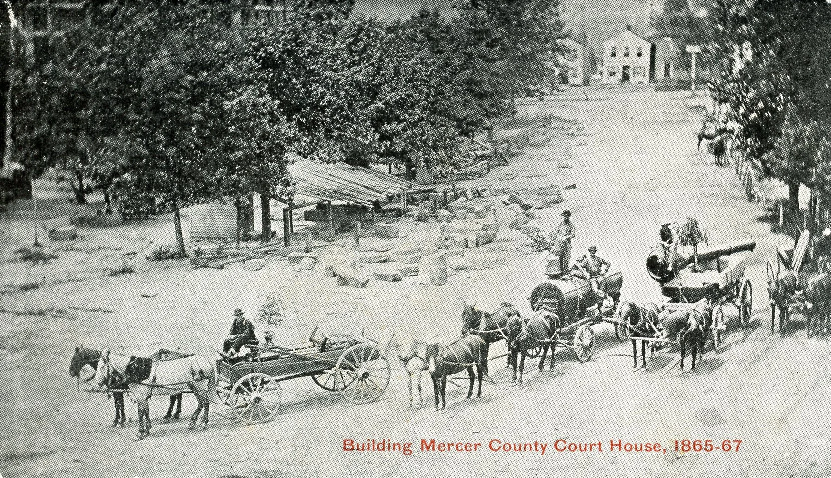 A black and white historical photograph showing a group of people and horses hitched to wagons, in front of the Mercer County Courthouse from 1865-67. The courthouse is at the top of a hill, surrounded by trees, with a path or road in the foreground.