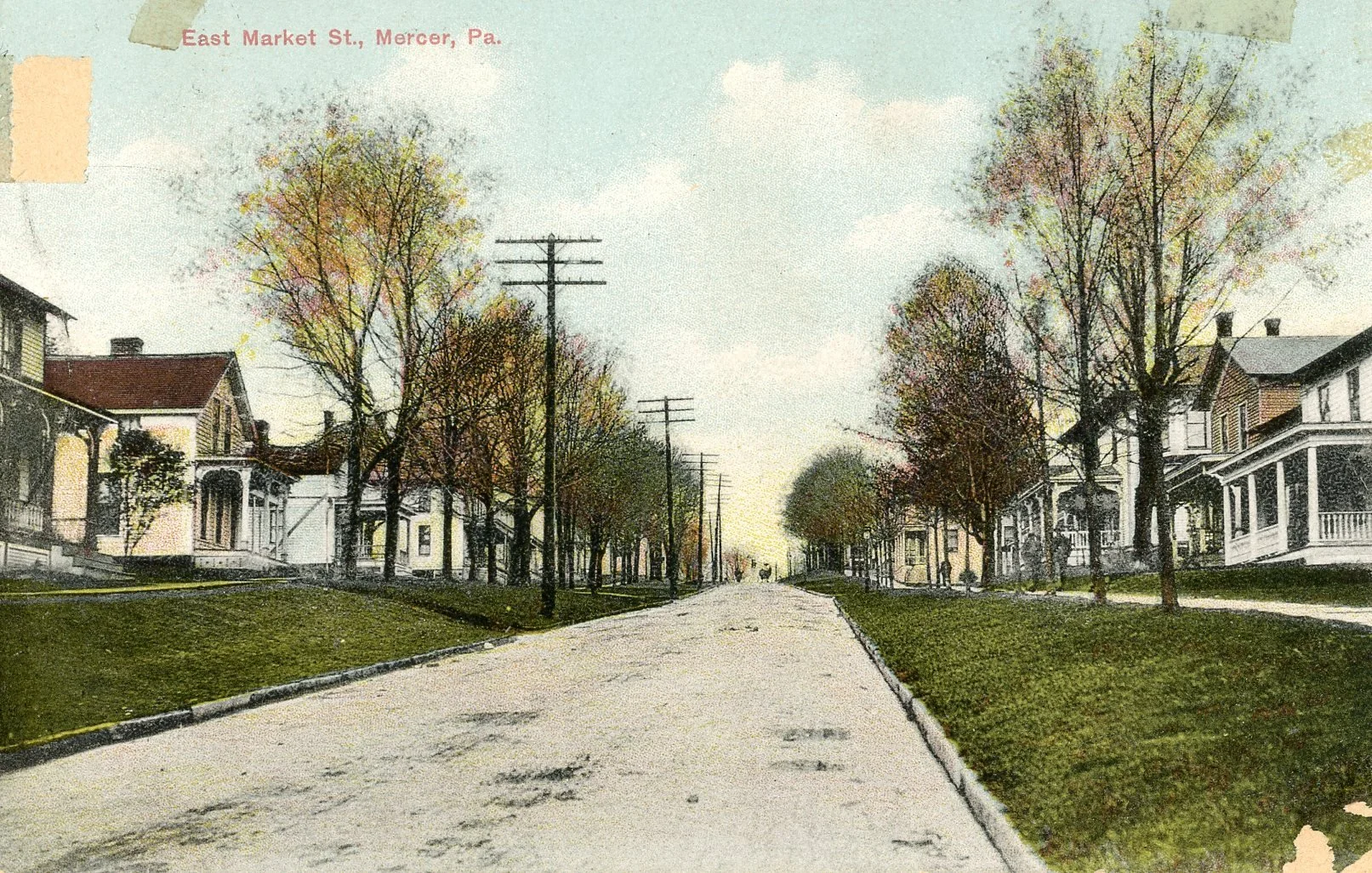 A vintage colorized photograph of East Market Street in Mercer, Pennsylvania, featuring a tree-lined street with houses on both sides and telephone poles along the sidewalk.