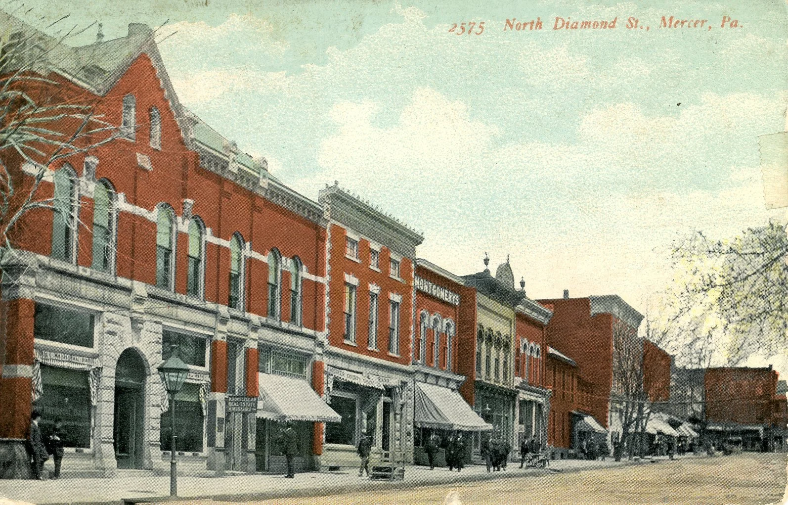 A vintage street scene in Mercer, Pennsylvania, with brick buildings, storefronts, and pedestrians, from North Diamond Street.
