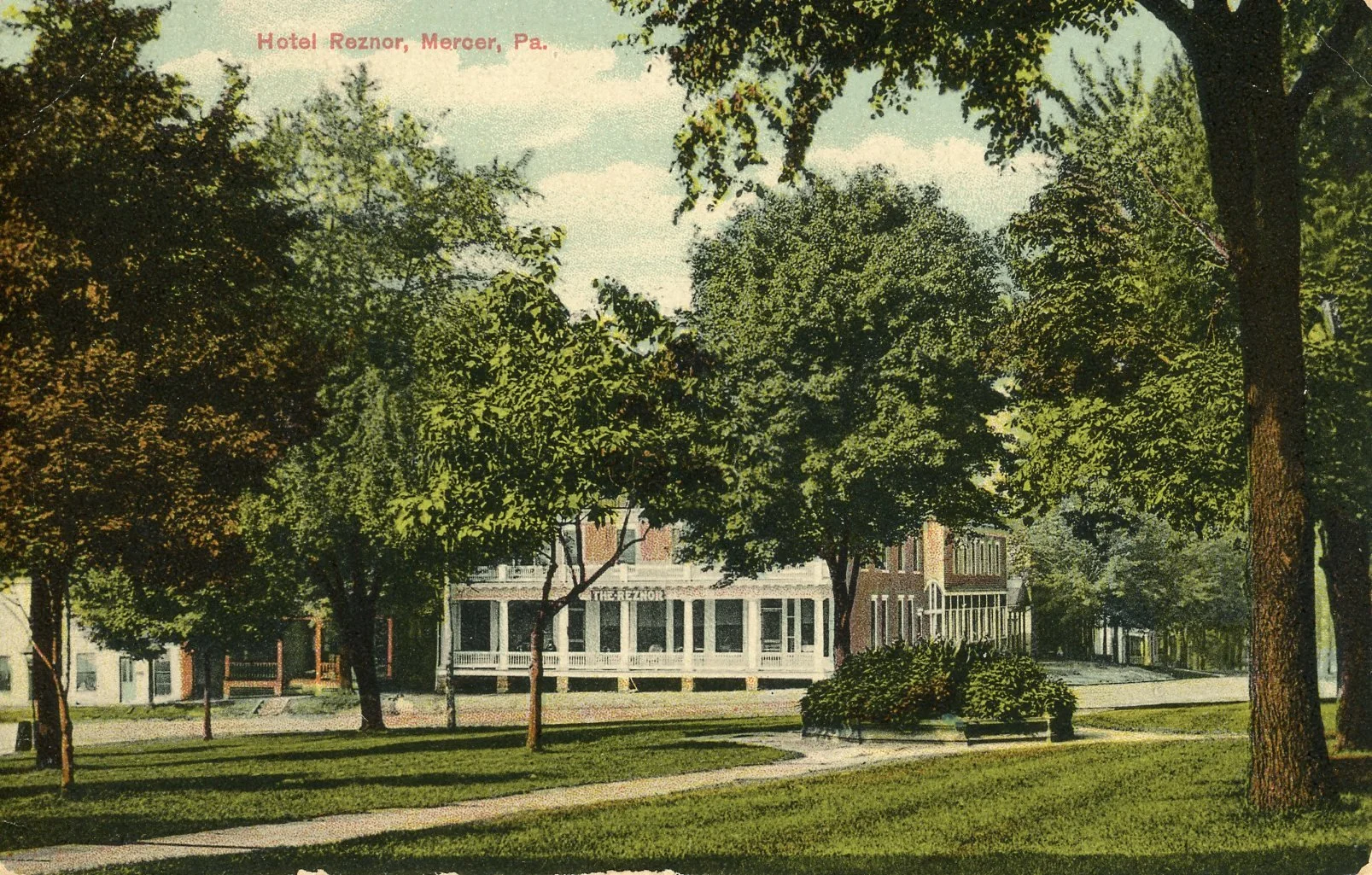 A historic building labeled 'Hotel Reznor' in Mercer, Pennsylvania, surrounded by trees and a well-maintained park with benches and grass.