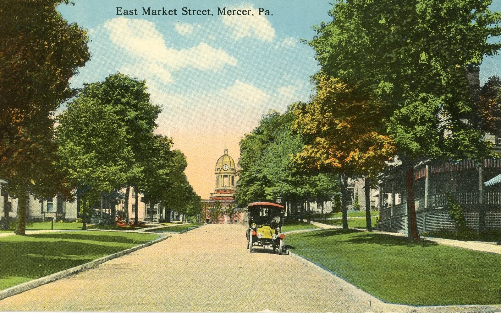 A historical postcard of East Market Street in Mercer, Pennsylvania, showing a tree-lined street with a vintage car parked on the side and a domed building in the distance under a blue sky with clouds.