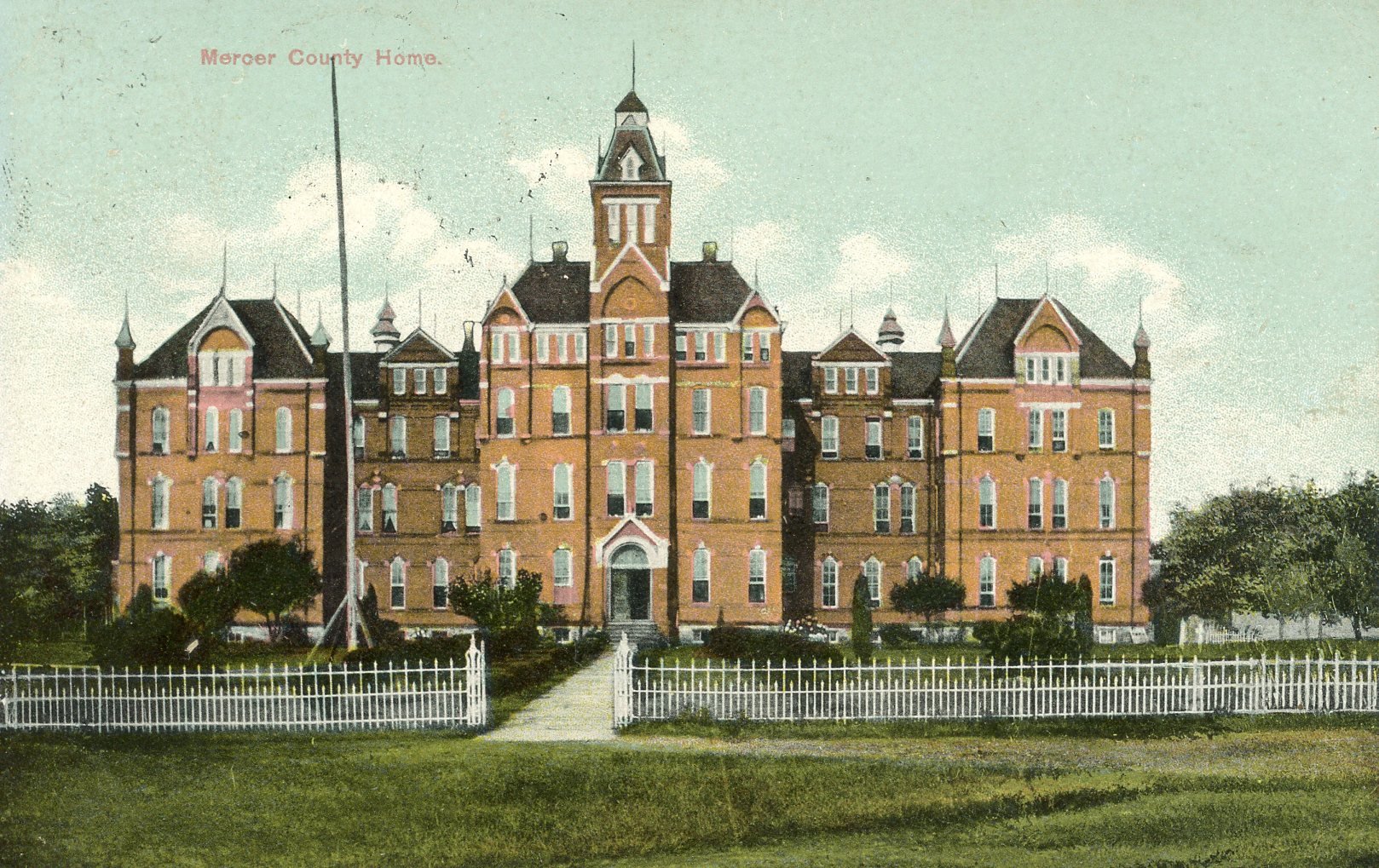 Colorized vintage photograph of the Mercer County Home, a large Victorian-style brick building with pointed turrets, a central tower, white trim, and a white picket fence surrounding a well-maintained lawn.