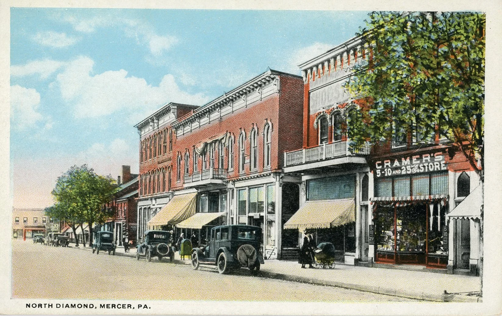 Vintage street scene of North Diamond, Mercer, Pennsylvania, with brick buildings, storefronts with yellow awnings, vintage cars, pedestrians, and trees under a partially cloudy sky.