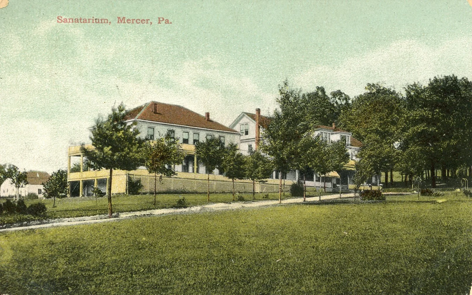 Vintage postcard of a large white house with a red roof, surrounded by a park with trees and a walking path, labeled 'Sanatorium, Mercer, Pa.'