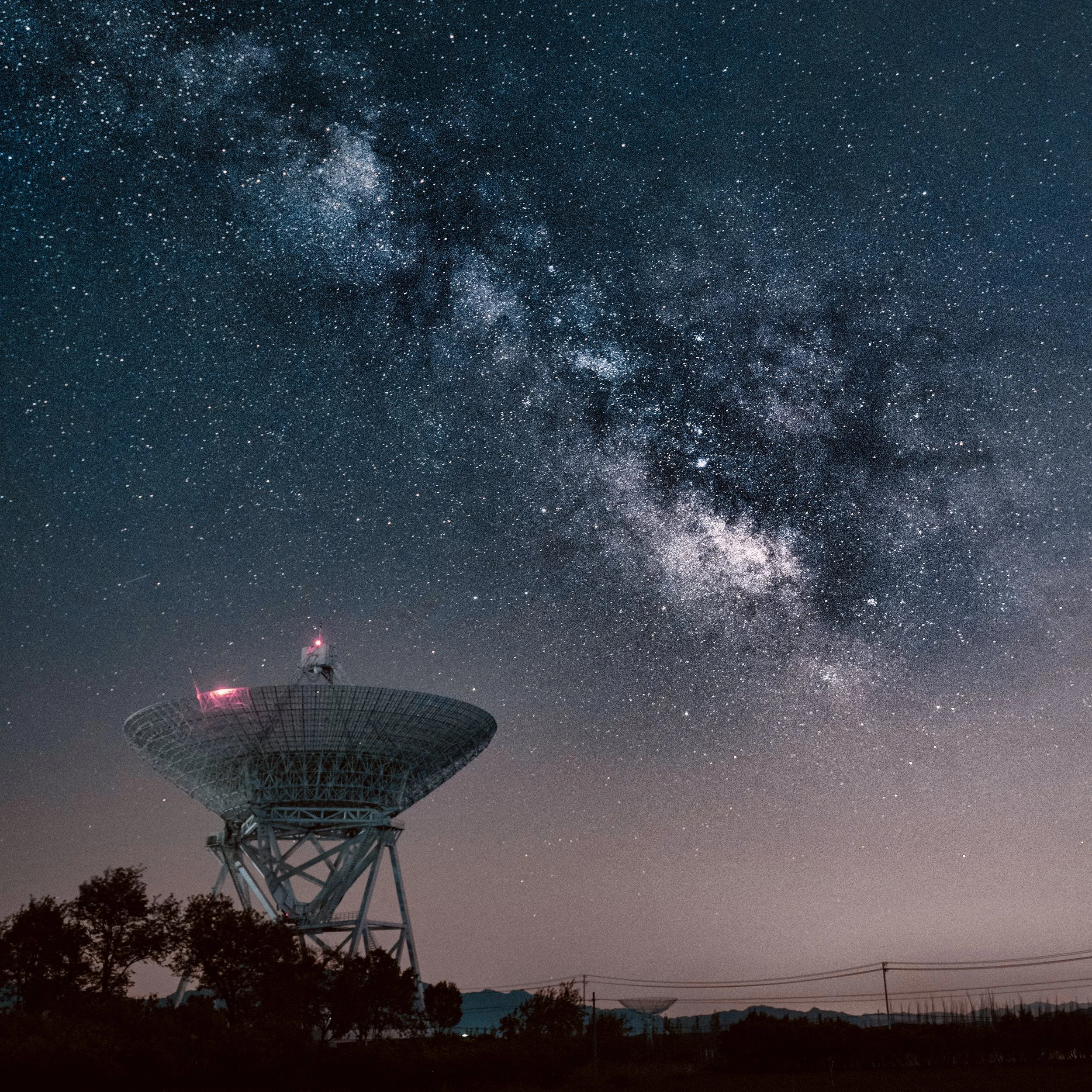 Funkkommunikationsturm unter sternenbedecktem Himmel mit der Milchstraße im Hintergrund. Senden Sie ein Signal!
