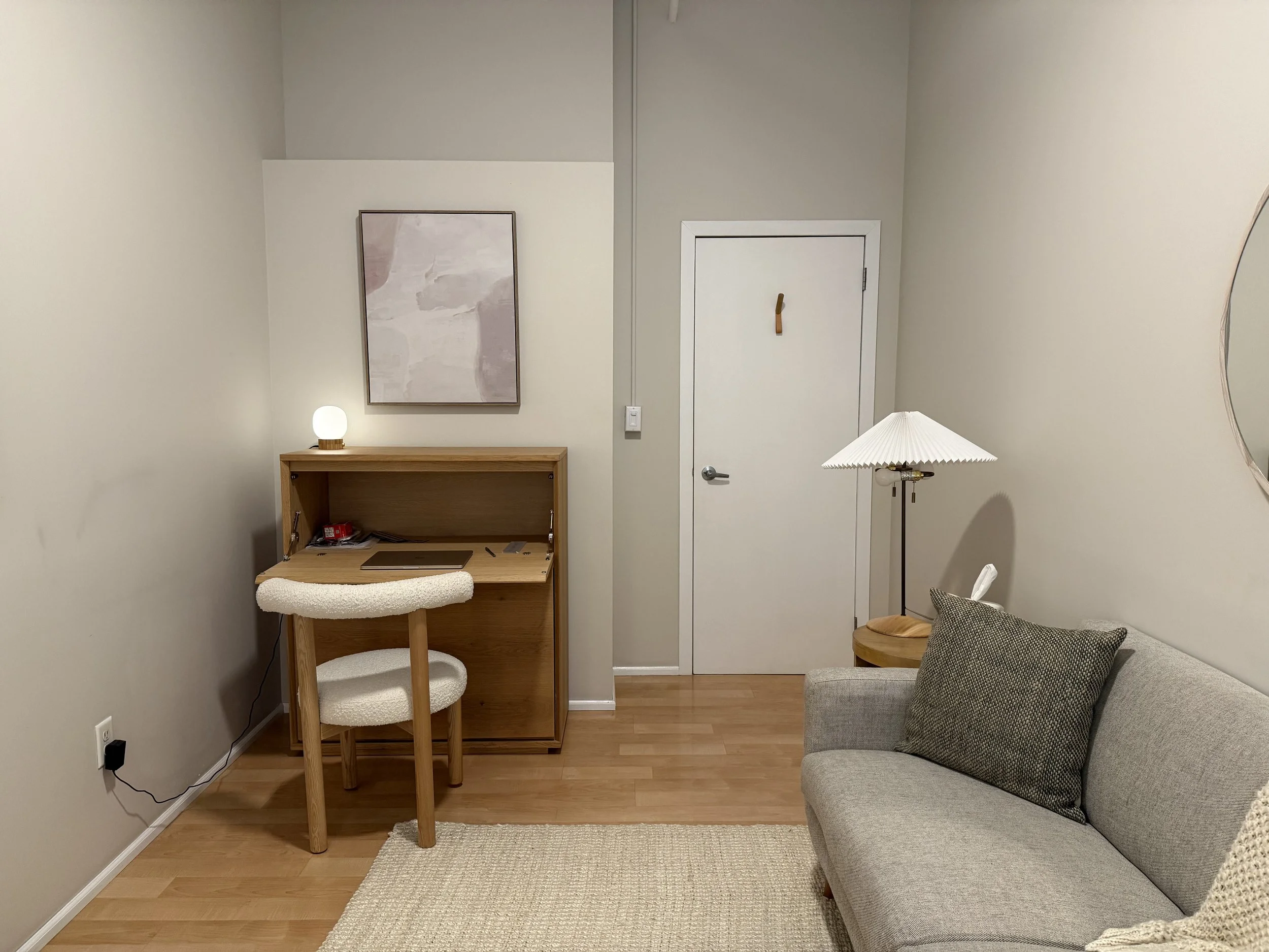Shruthi a South Asian anxiety therapist's NYC office which includes a desk, chair, and couch