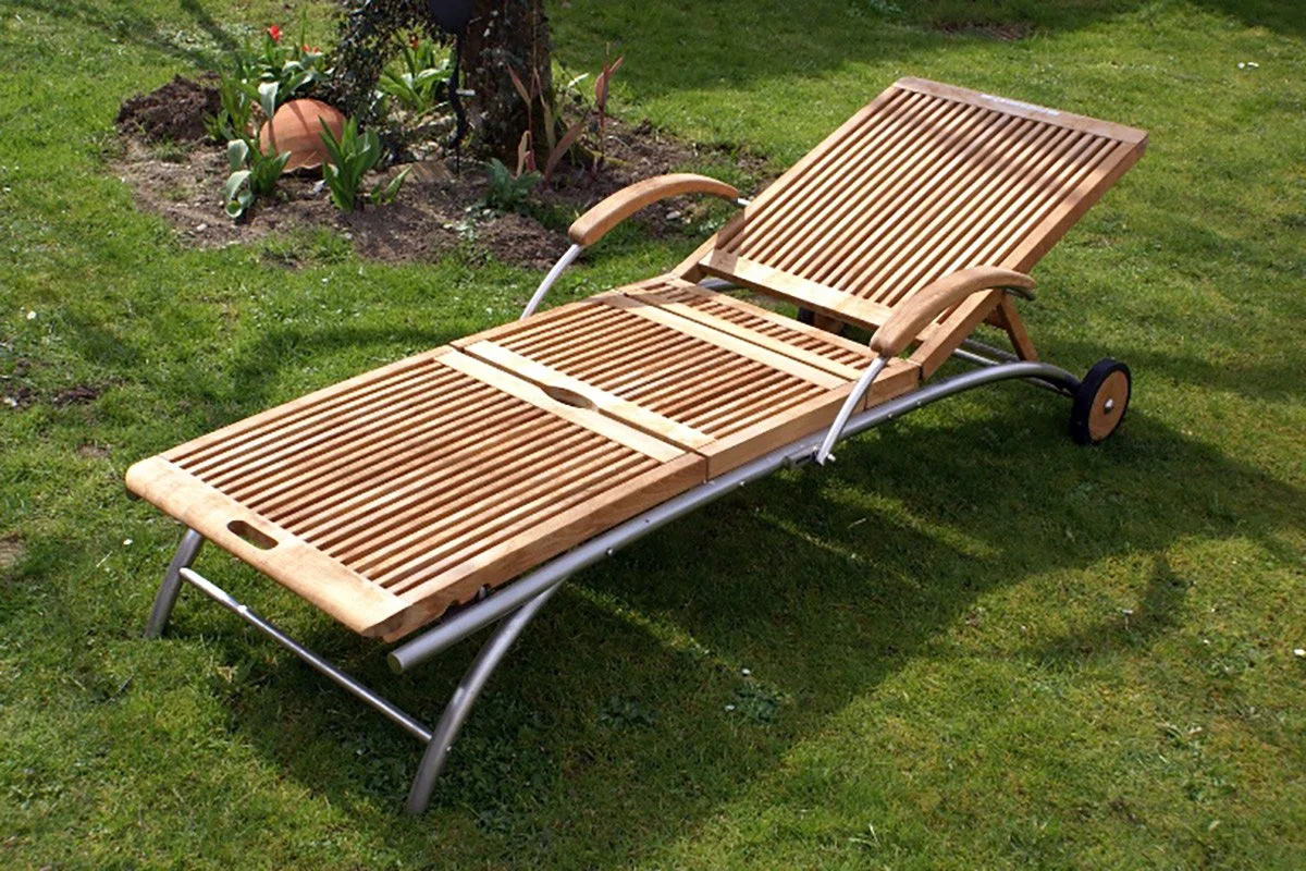 Gartenliege aus Holz mit verstellbarer Rückenlehne auf grünem Rasen.