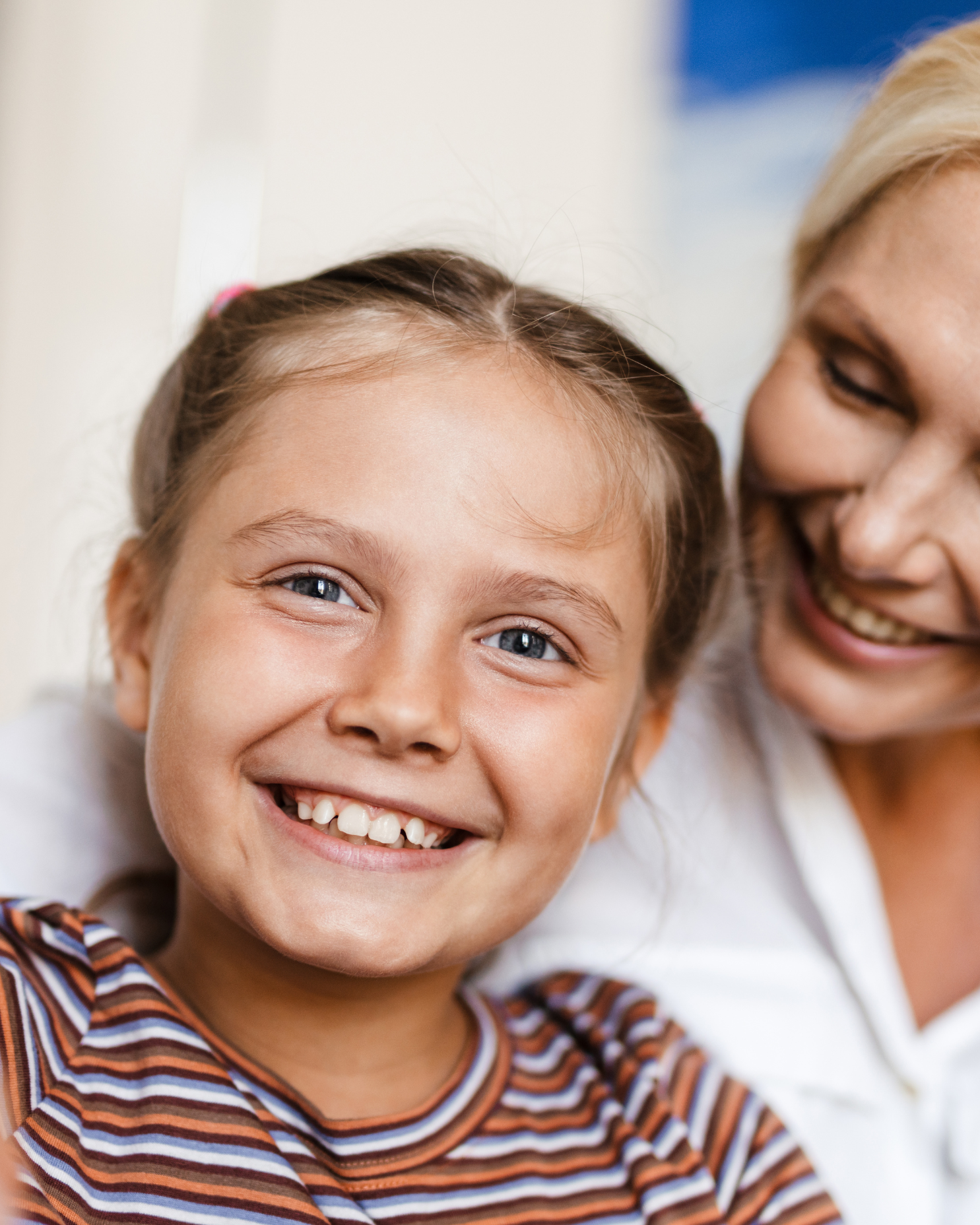 Girl and mother smiling at camera